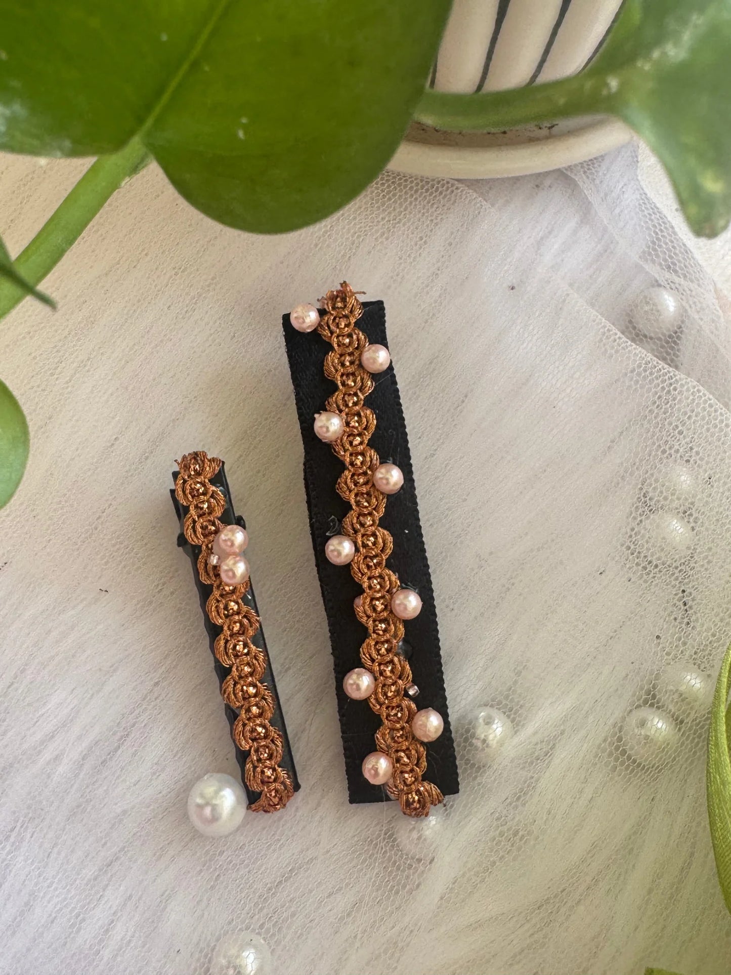 Pearl embroidered hair clips in golden tint by Bows and Bags India, handmade accessory detail shot on white fabric