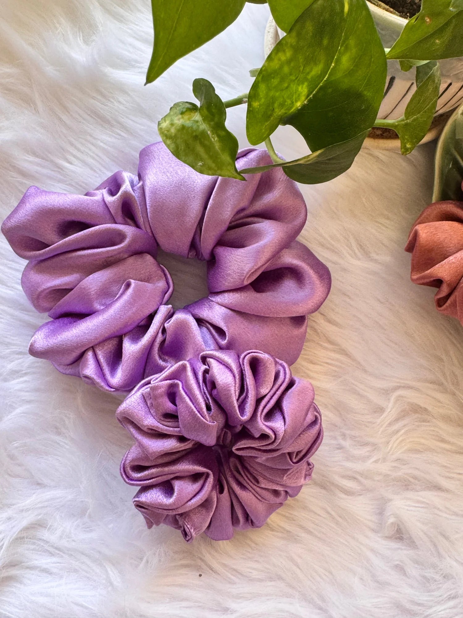 Lavender satin scrunchies duo in large and small sizes displayed on white fur, showing soft fluffy texture and handmade