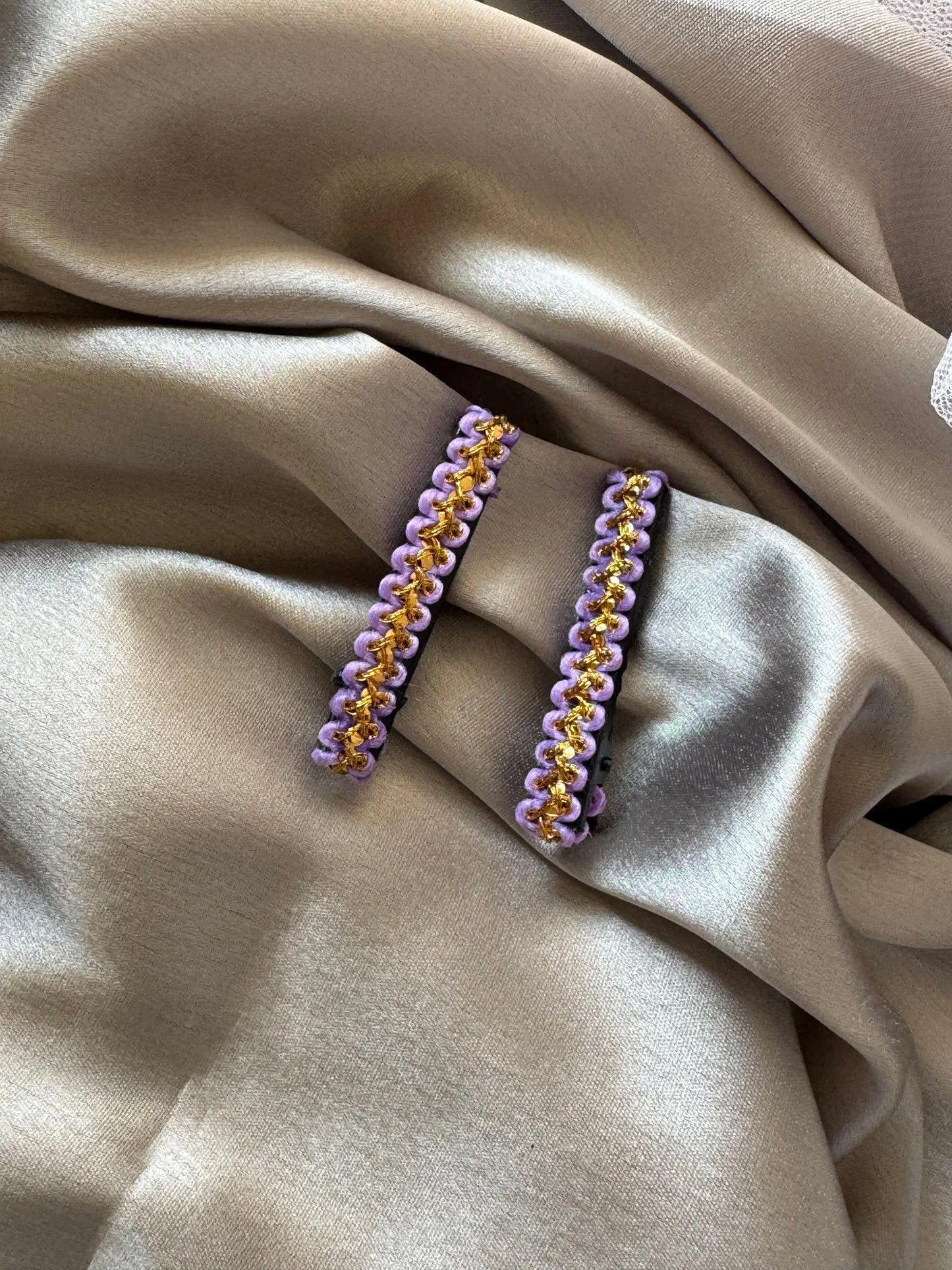 Pair of lavender and gold handmade hair clips by Bows and Bags India displayed on neutral fabric, showing elegant beaded
