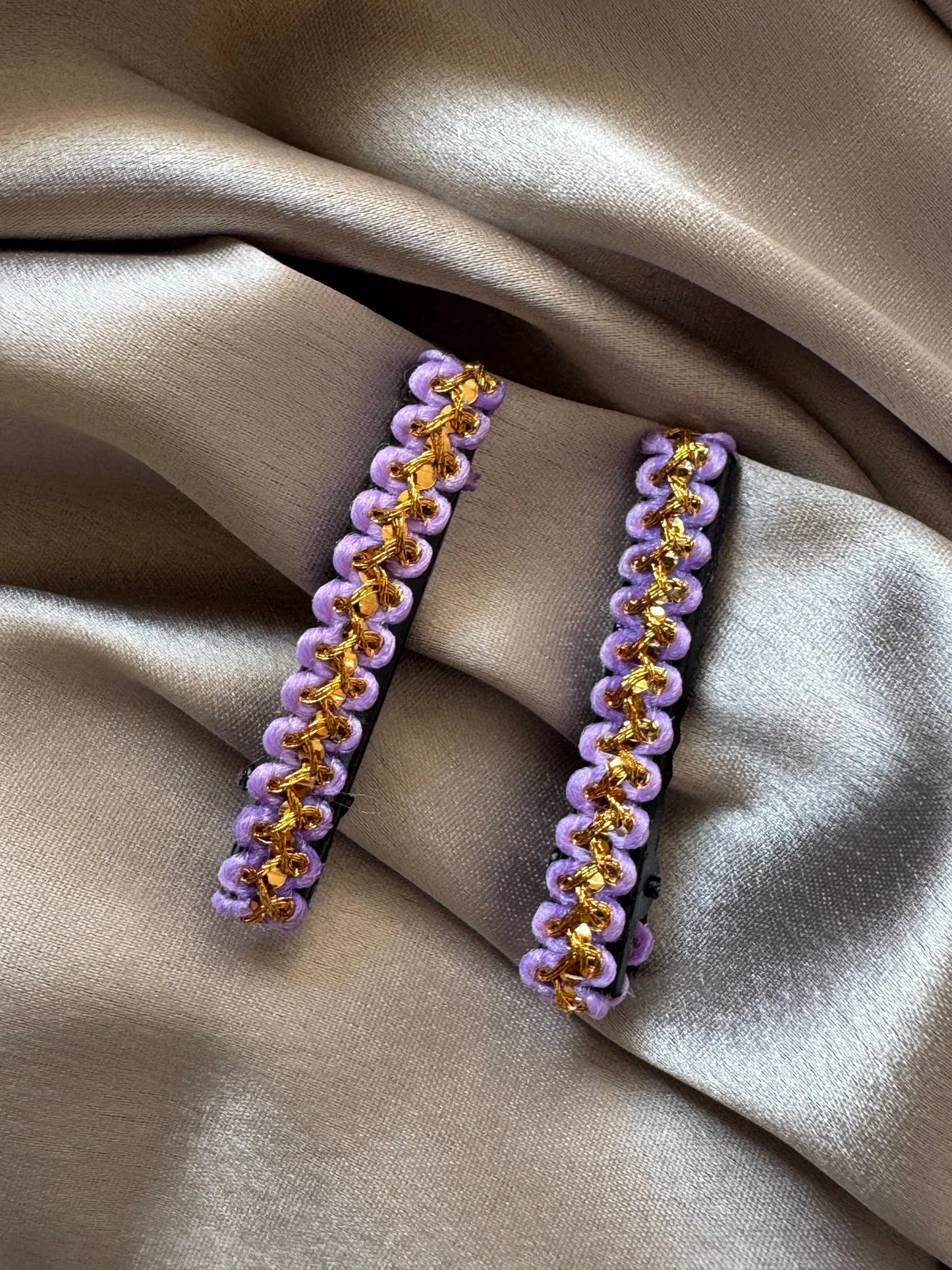 Pair of lavender and gold handmade hair clips by Bows and Bags India displayed on neutral fabric, showing intricate beaded