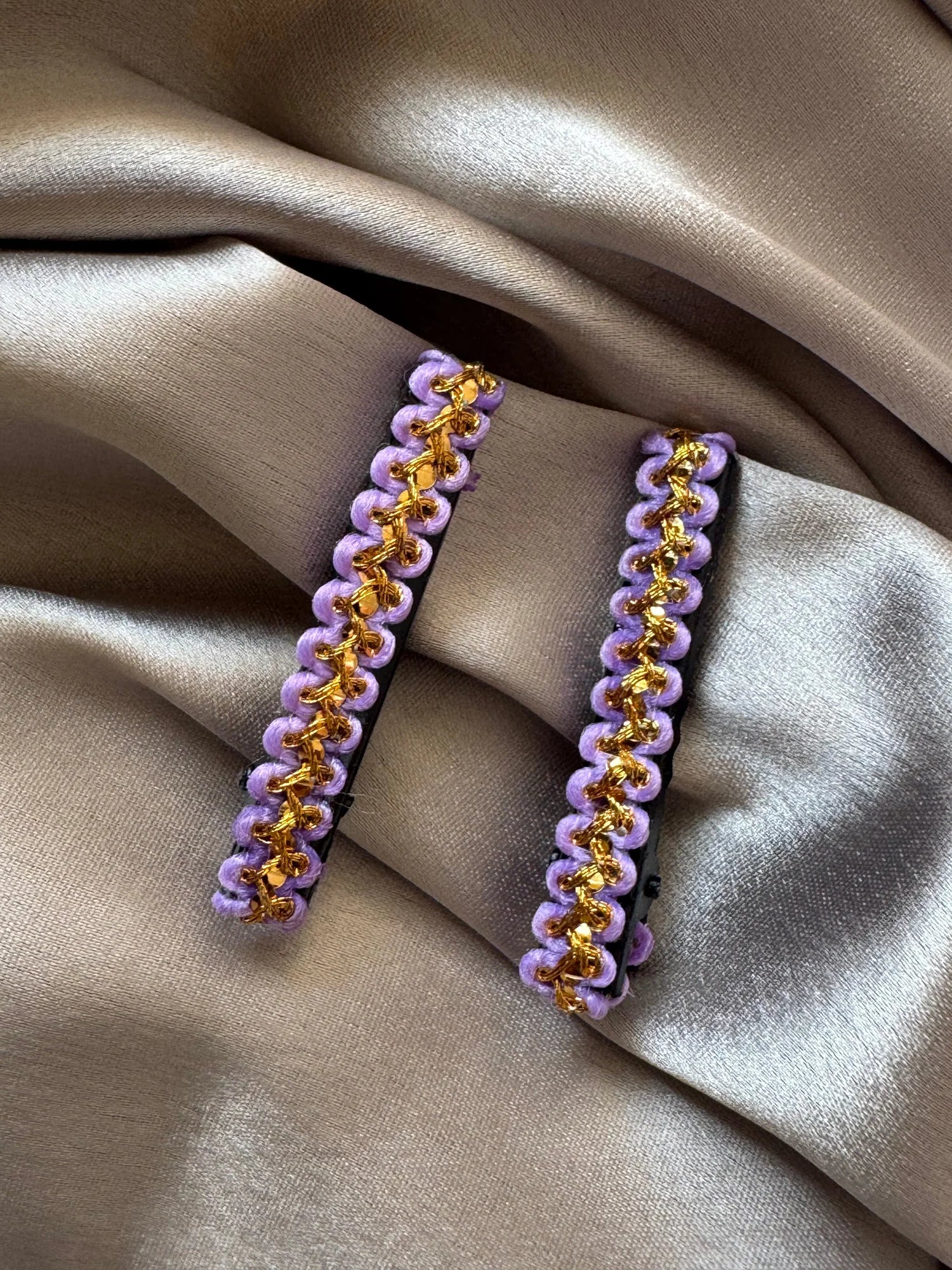 Pair of lavender and gold handmade hair clips by Bows and Bags India displayed on neutral fabric, showing intricate beaded