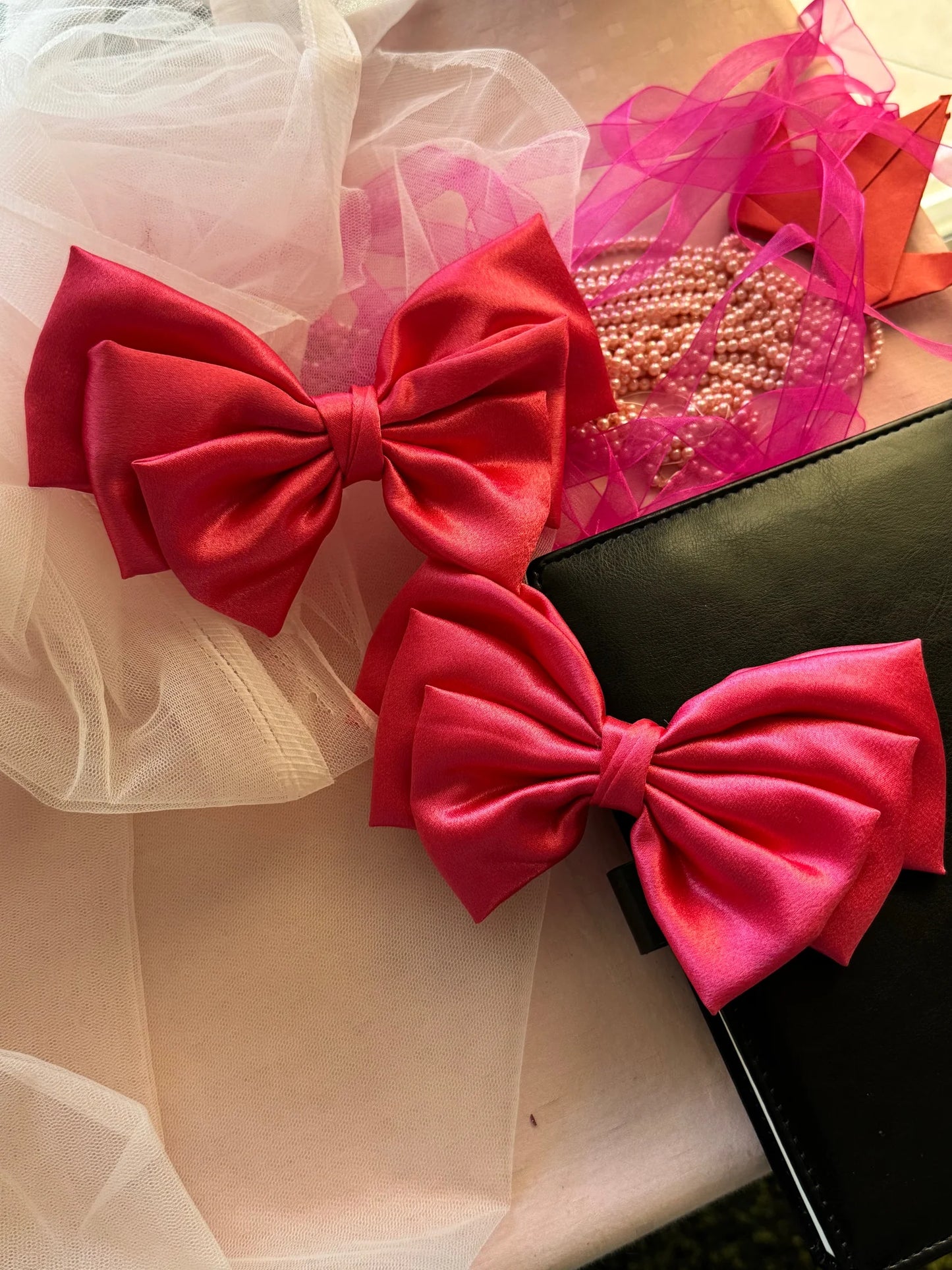 Hot pink satin hair bows with alligator clips by Bows and Bags India, displayed with pearl beads and tulle accessories