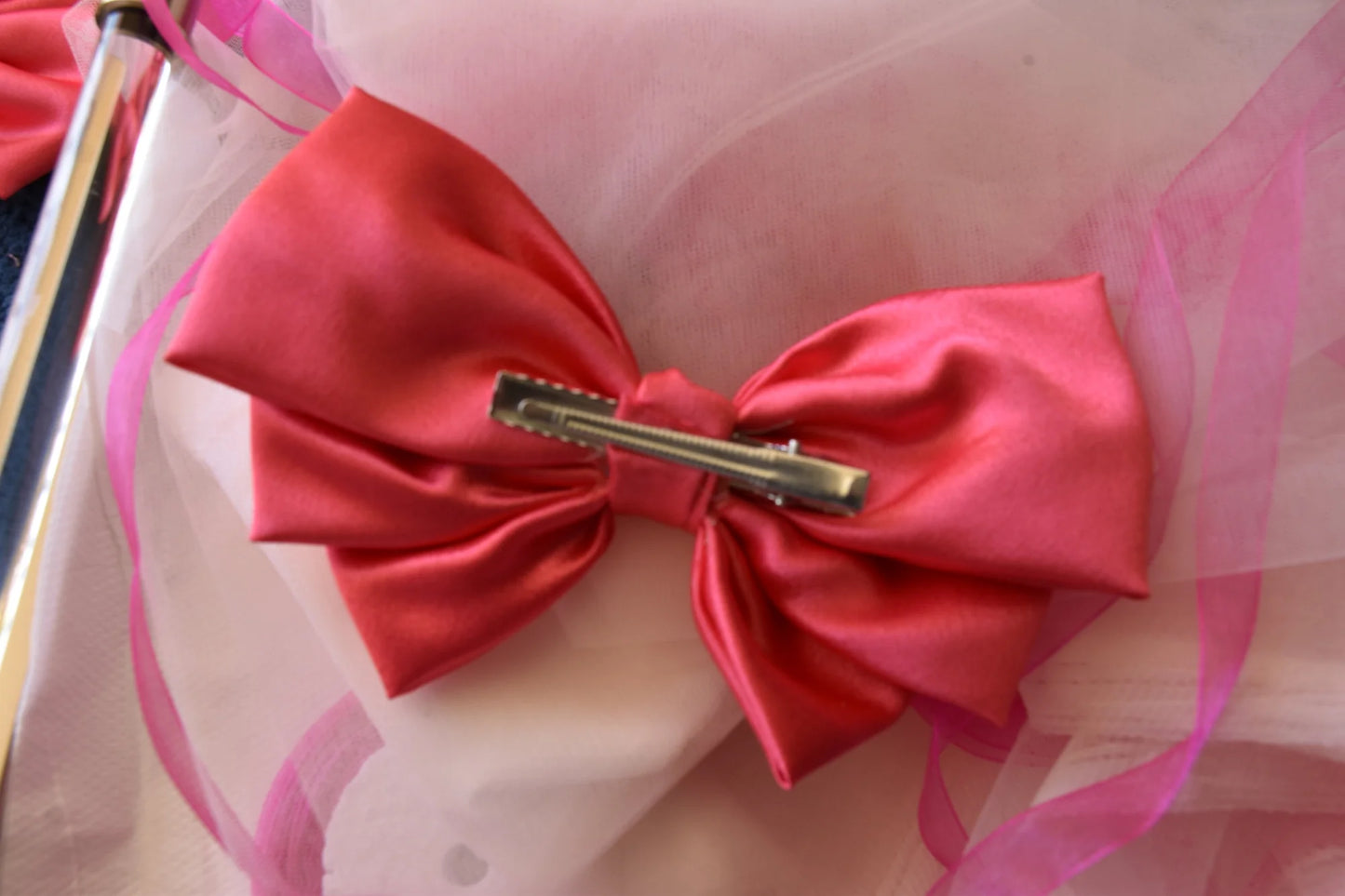 Hot pink satin hair bow by Bows and Bags India with gold clip detail on pink tulle backdrop