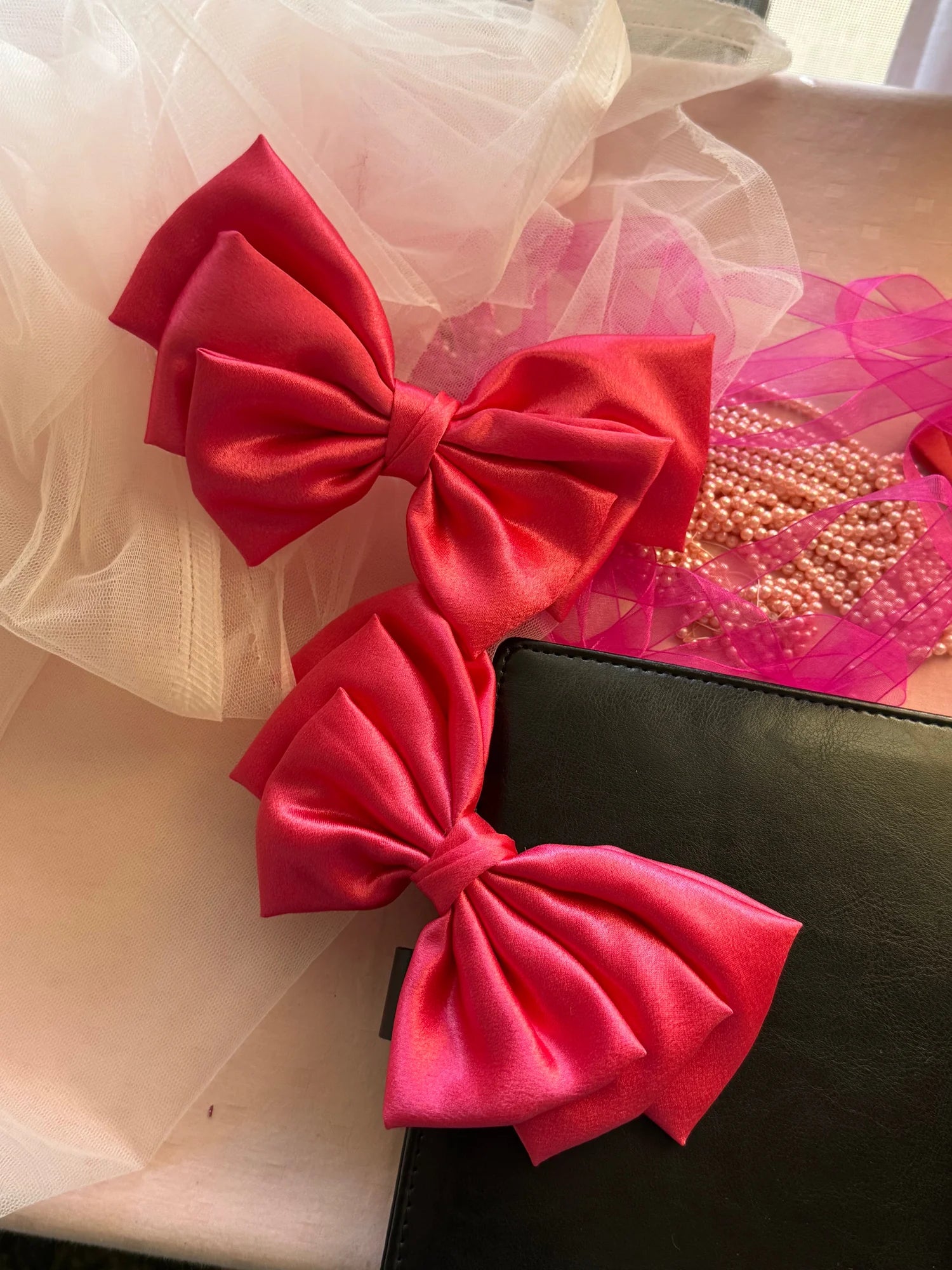 Hot pink satin hair bows by Bows and Bags India displayed with tulle and beaded accessories, handmade styling details
