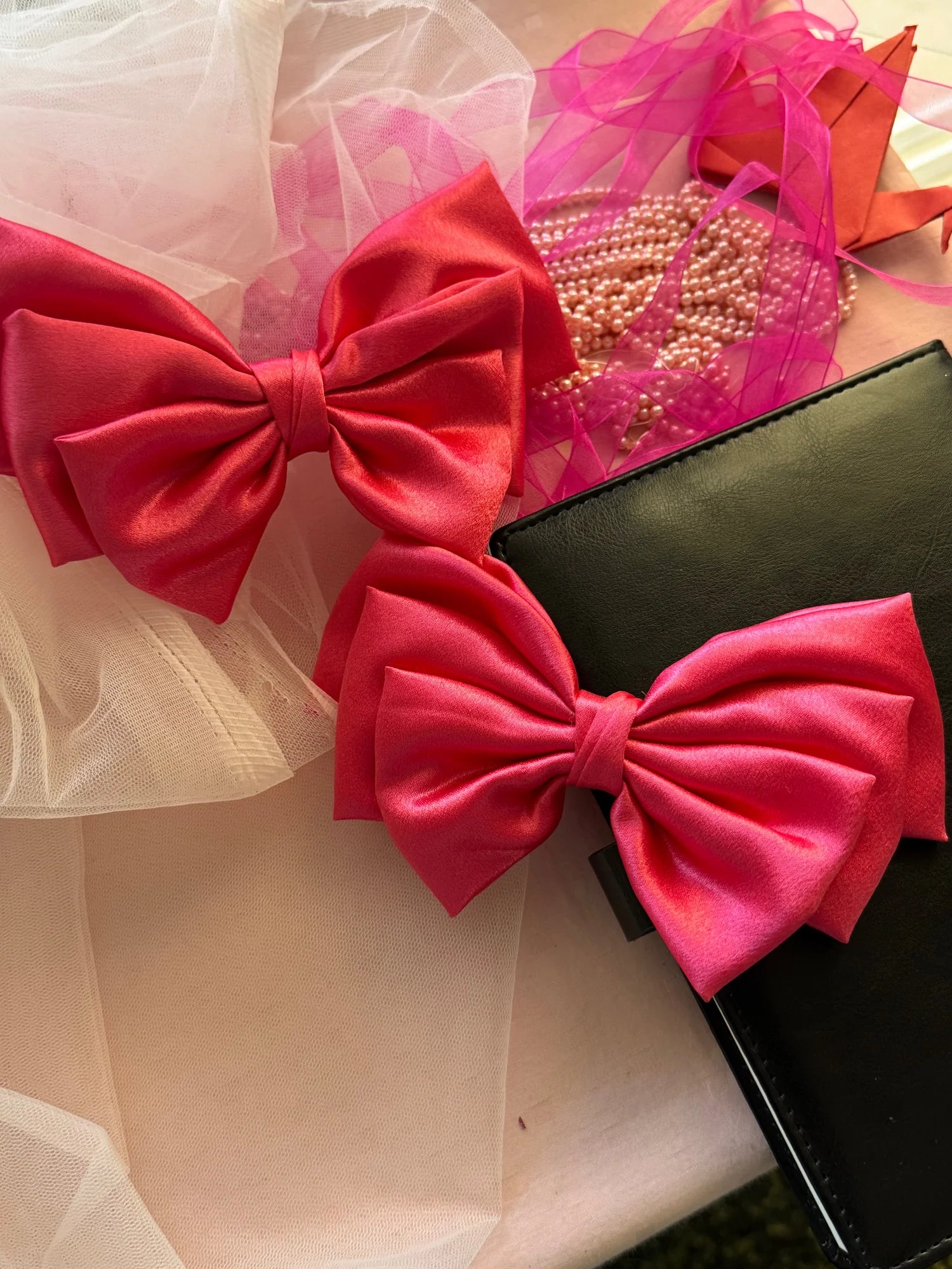 Hot pink satin hair bow by Bows and Bags India displayed with pearl beads and tulle styling details