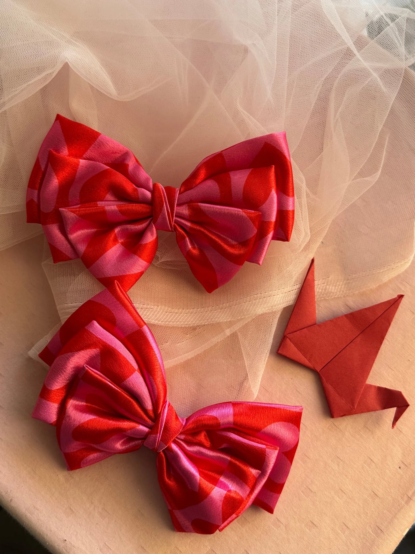 Love Struck printed satin hair bow in pink with heart patterns by Bows and Bags India, handmade hair accessory displayed on