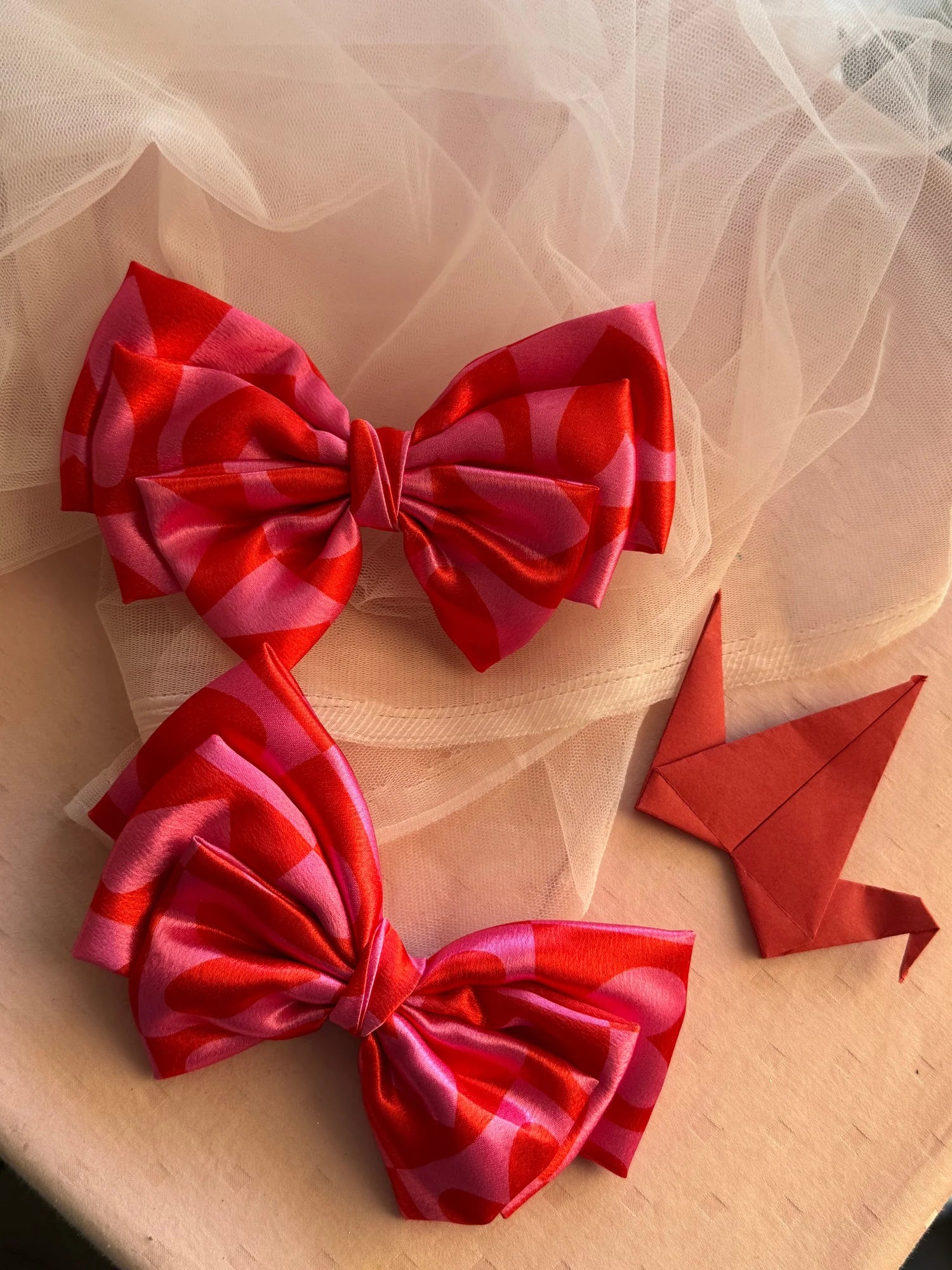 Love Struck printed satin hair bow in pink with heart patterns by Bows and Bags India, handmade hair accessory displayed on