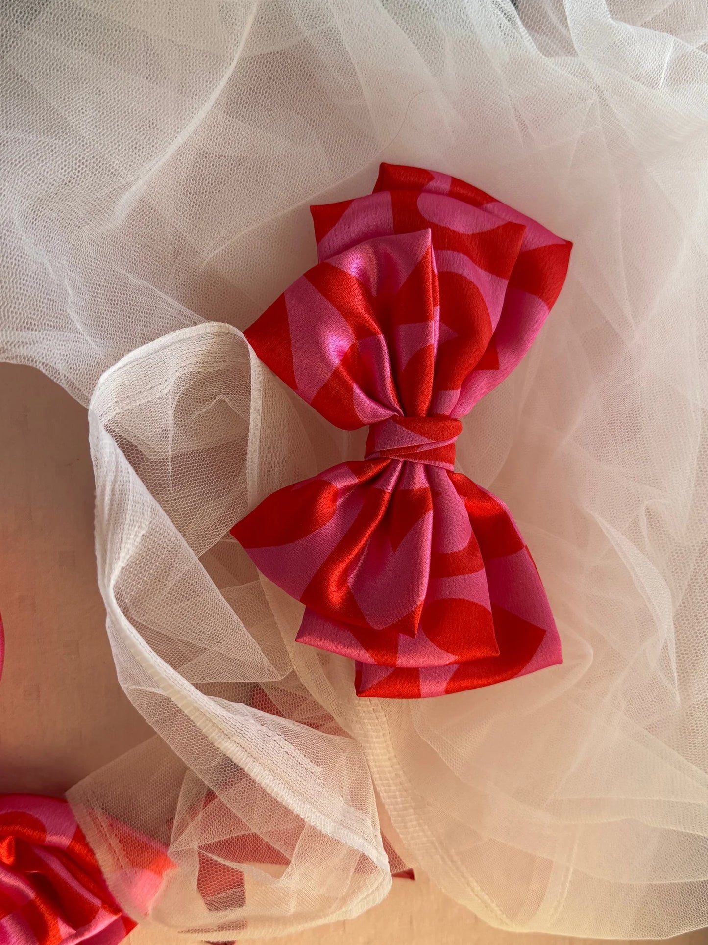 Love Stuck printed satin hair bow in pink with heart details, handmade accessory by Bows and Bags India on tulle fabric