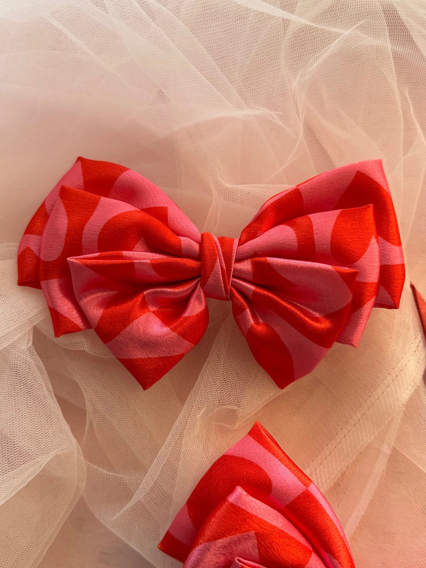 Love Stuck printed satin hair bow with pink heart design and glossy finish by Bows and Bags India