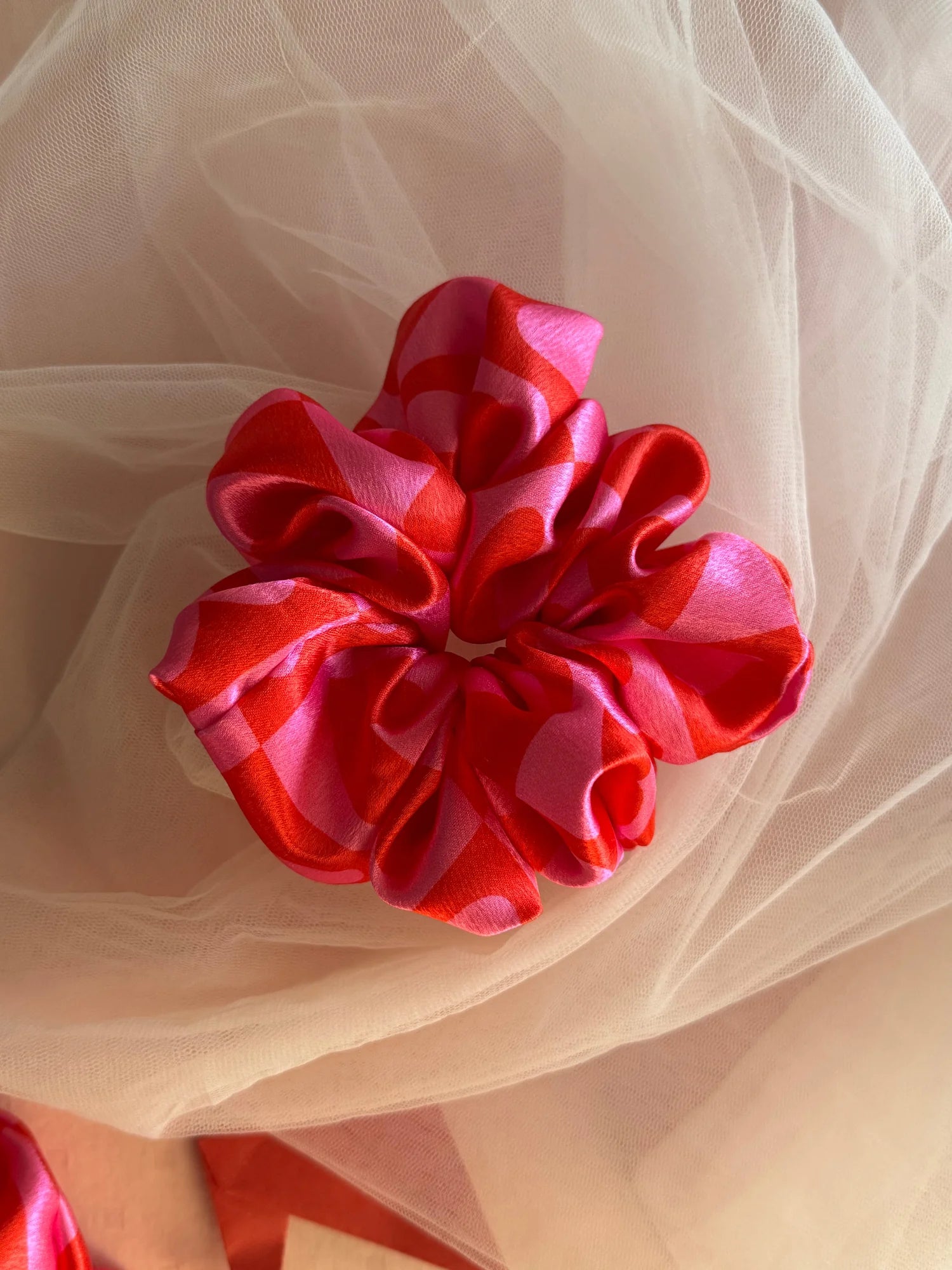 Love Stuck pink satin scrunchie with heart print by Bows and Bags India, displayed on sheer tulle fabric showing luxurious