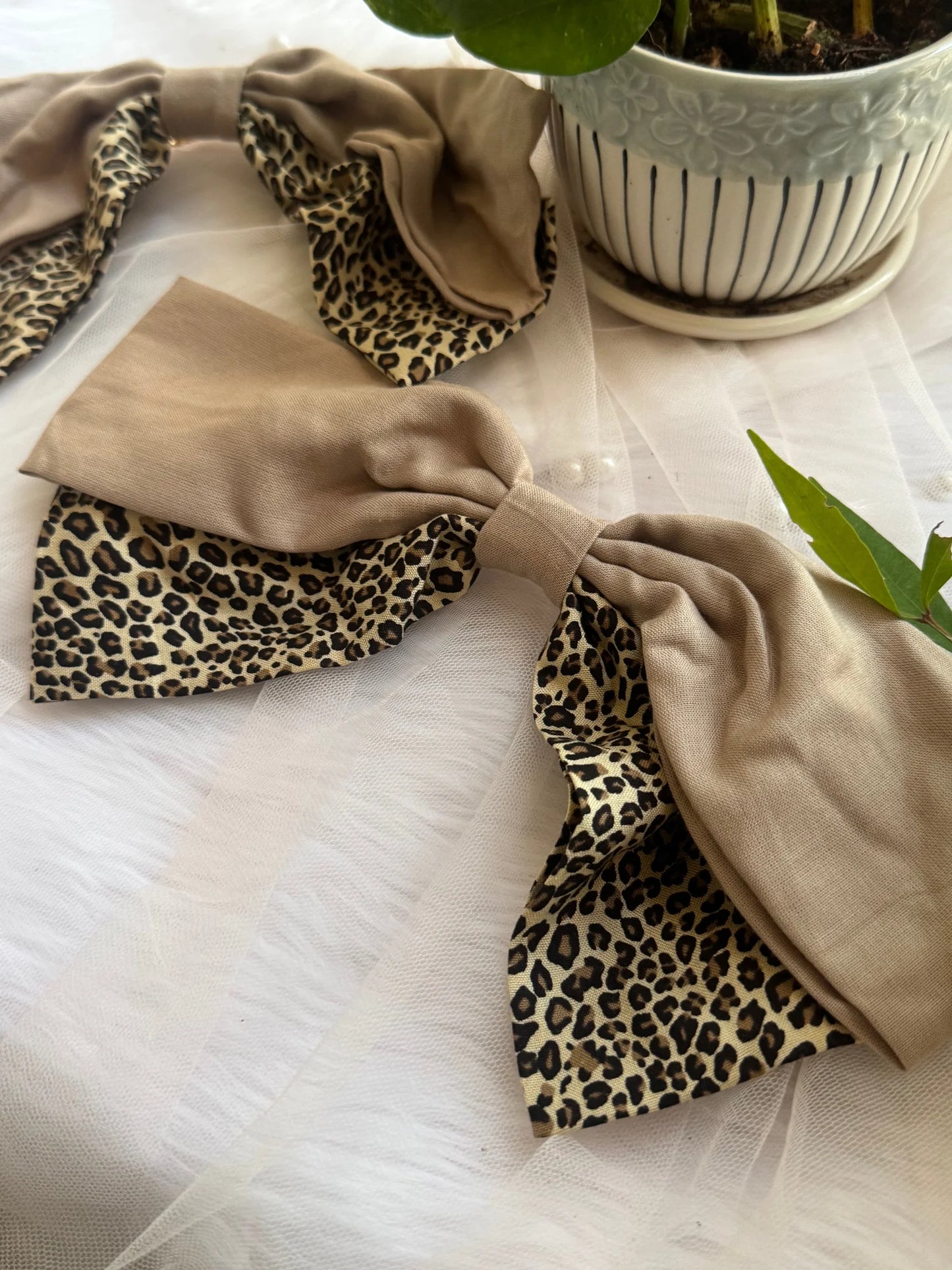 Beige and leopard print Madonna hair bow with satin finish displayed on white fabric by Bows and Bags India handmade hair