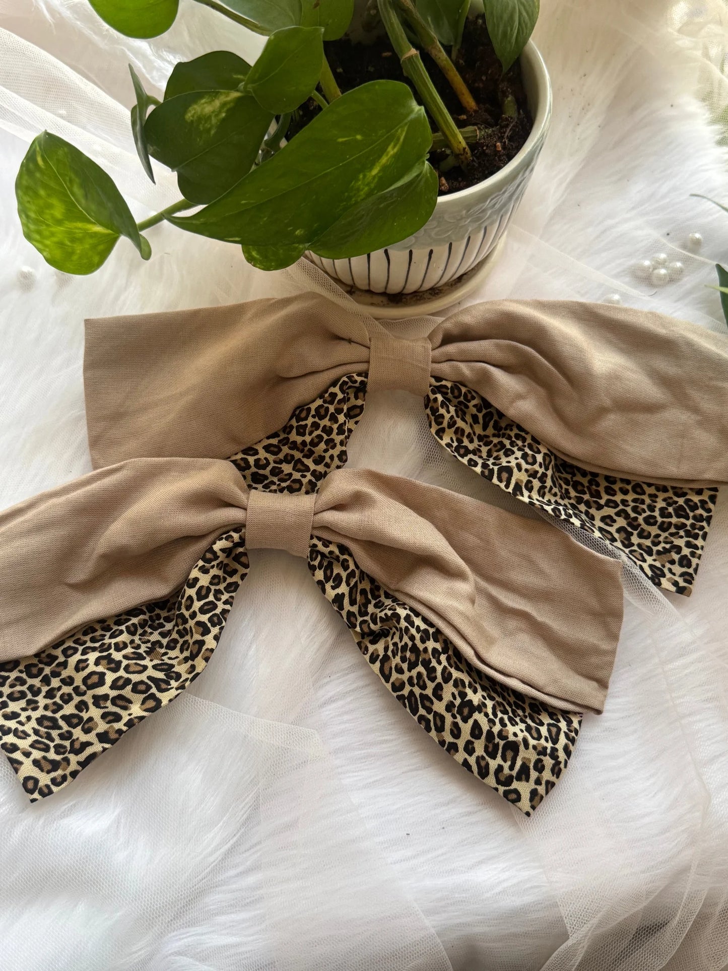Beige and leopard print Madonna hair bows displayed flat with potted plant, handmade hair accessories by Bows and Bags India
