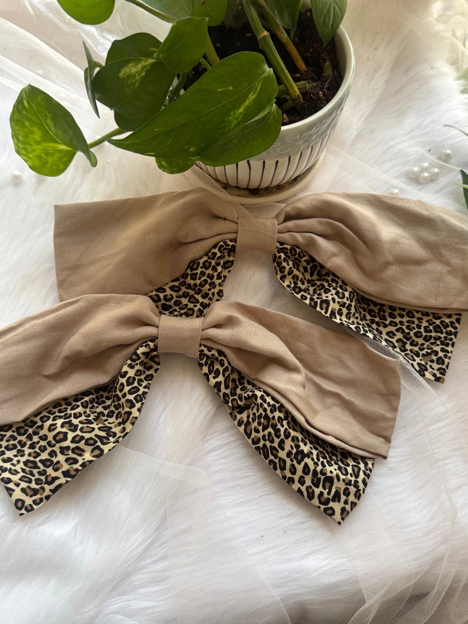 Beige and leopard print Madonna hair bows displayed flat with potted plant, handmade hair accessories by Bows and Bags India