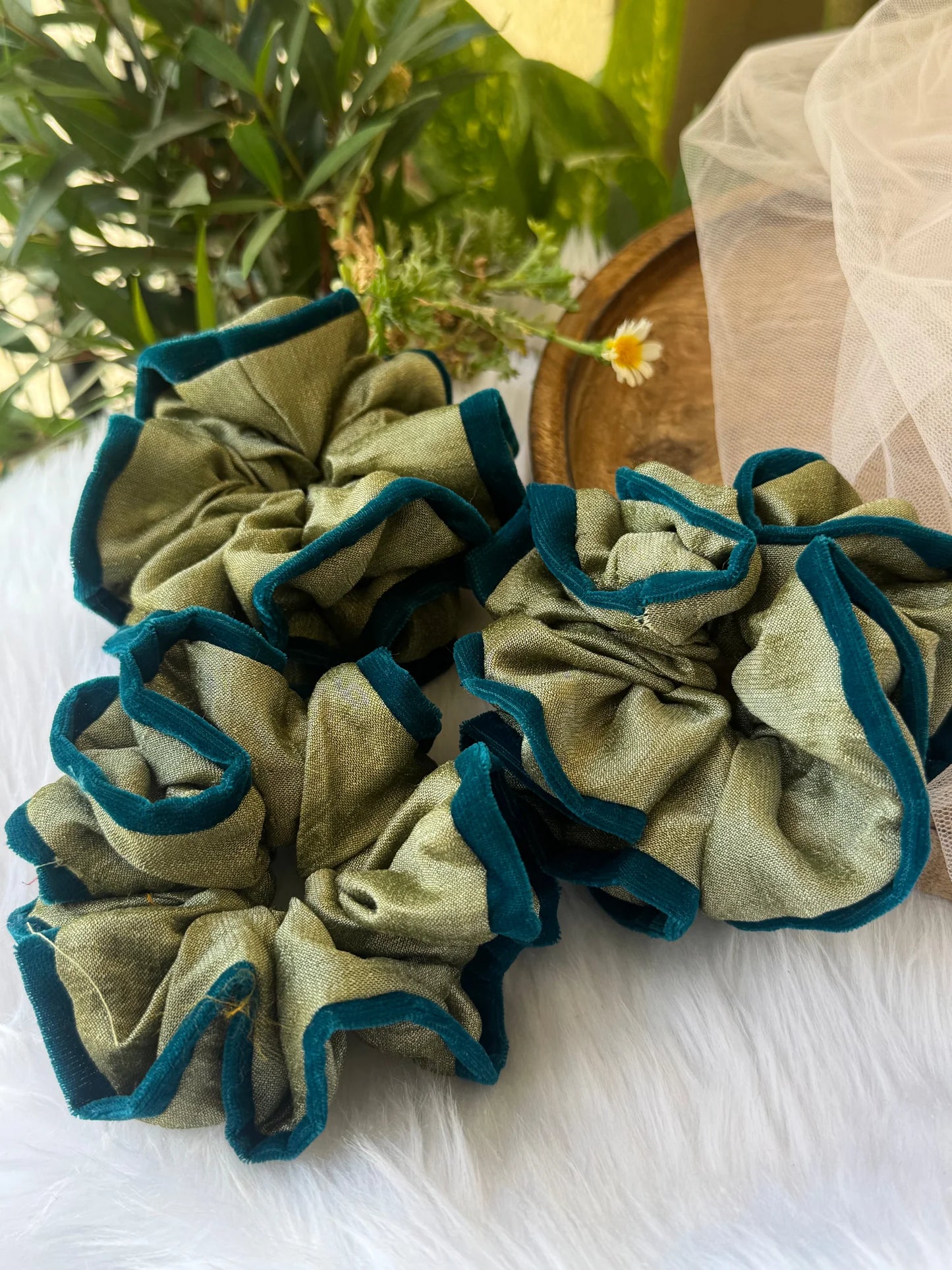Mint green silk and velvet scrunchie with dark teal outline, handmade by Bows and Bags India, displayed on white fabric with