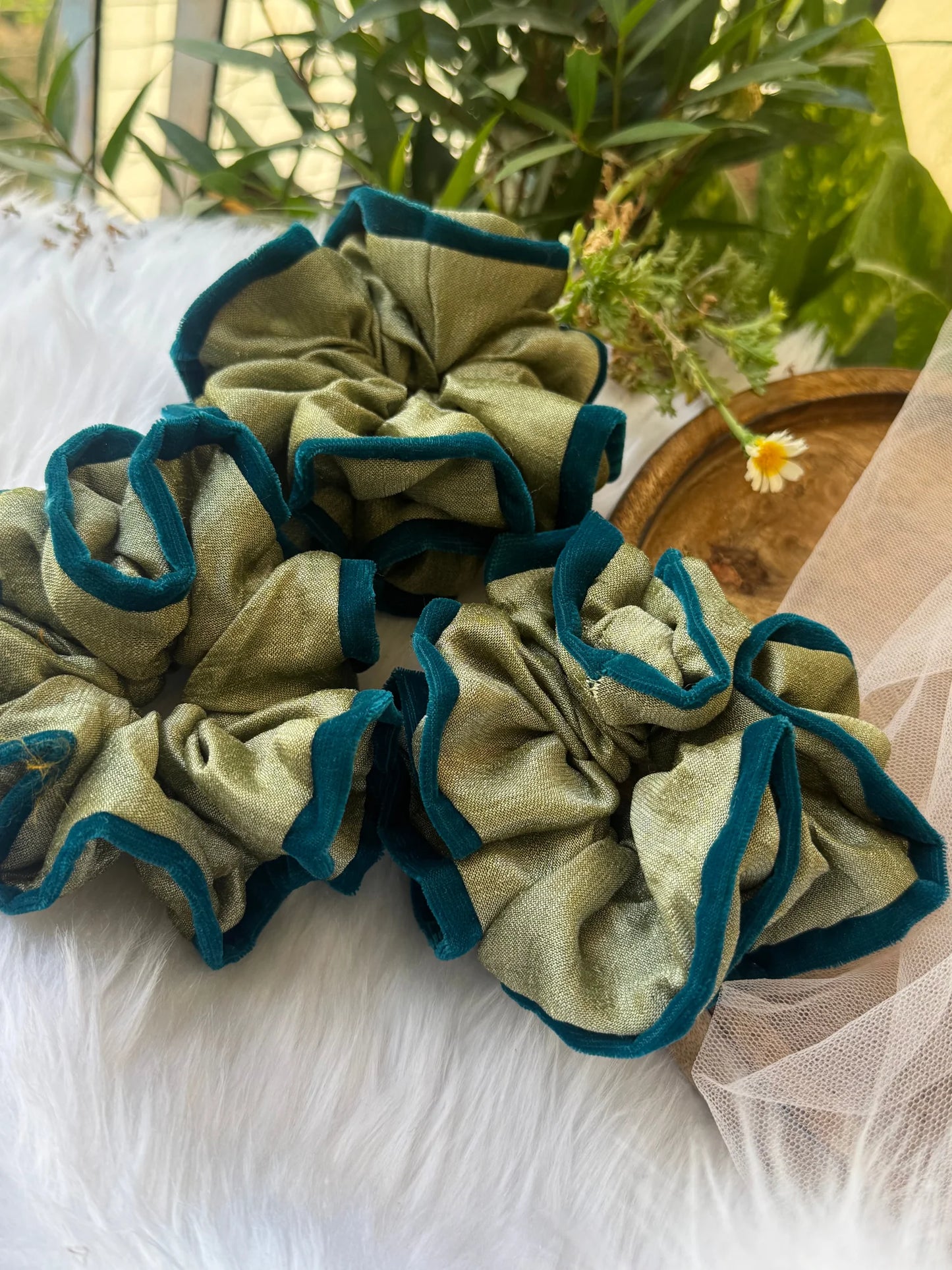 Mint green silk and velvet scrunchies bundle by Bows and Bags India displayed on white fur with potted plants, showing