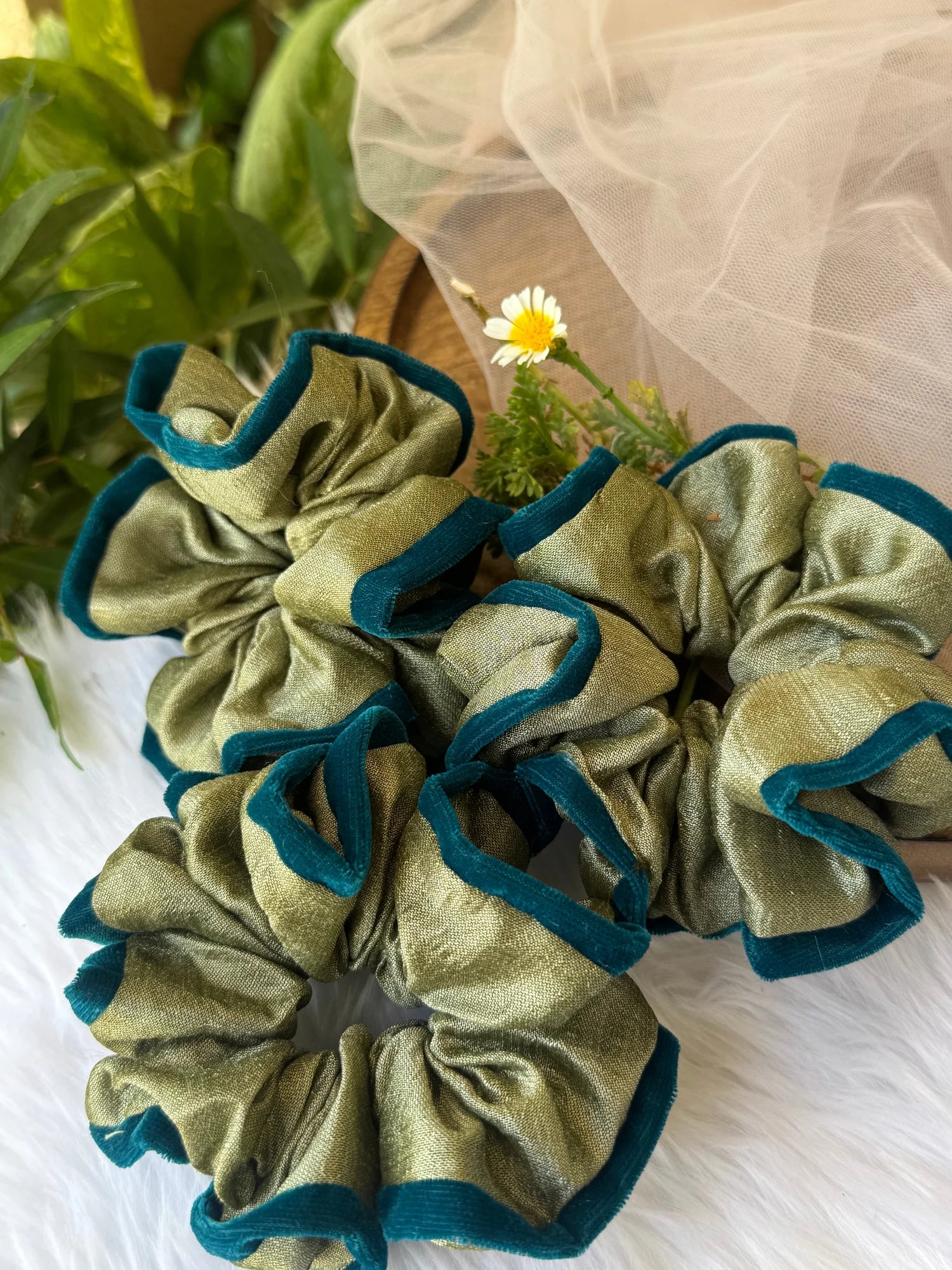 Mint green silk velvet handmade scrunchie with dark teal outline by Bows and Bags India, displayed on white fabric with