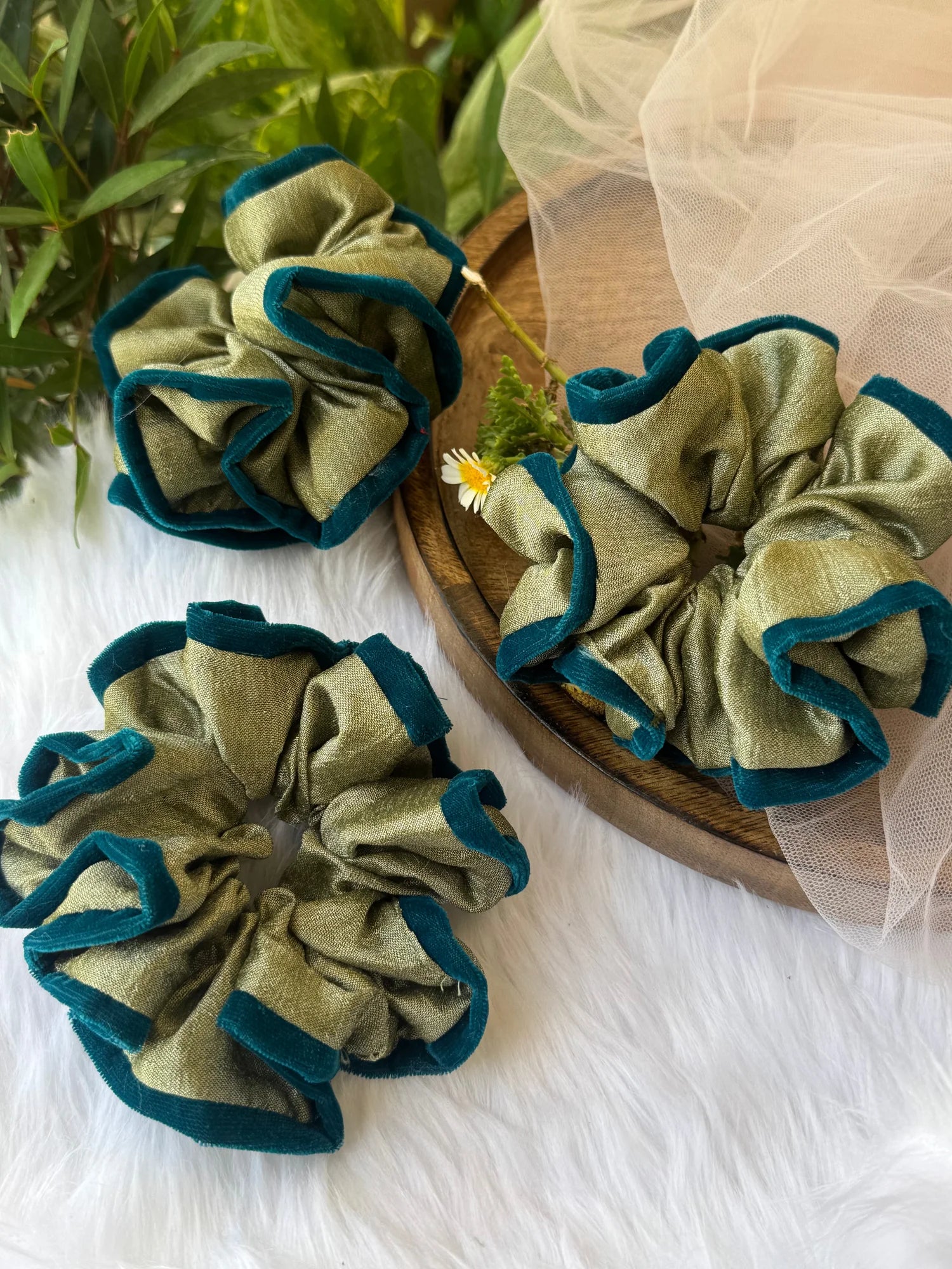 Mint green silk and velvet handmade scrunchies by Bows and Bags India displayed on wooden surface with tulle styling