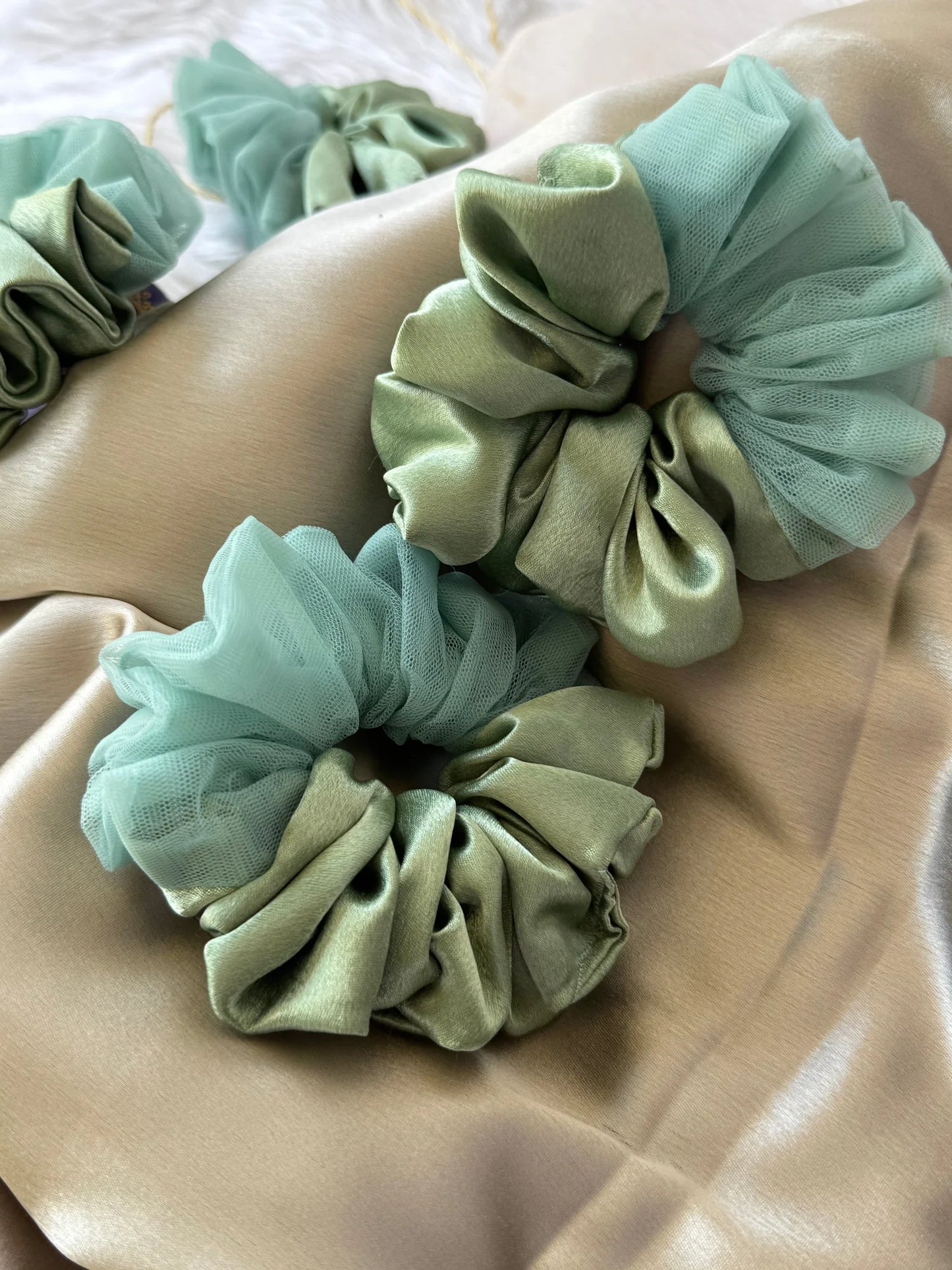 Mint green satin and net scrunchie with tulle ruffle detail displayed on arm, Bows and Bags India handmade hair accessory