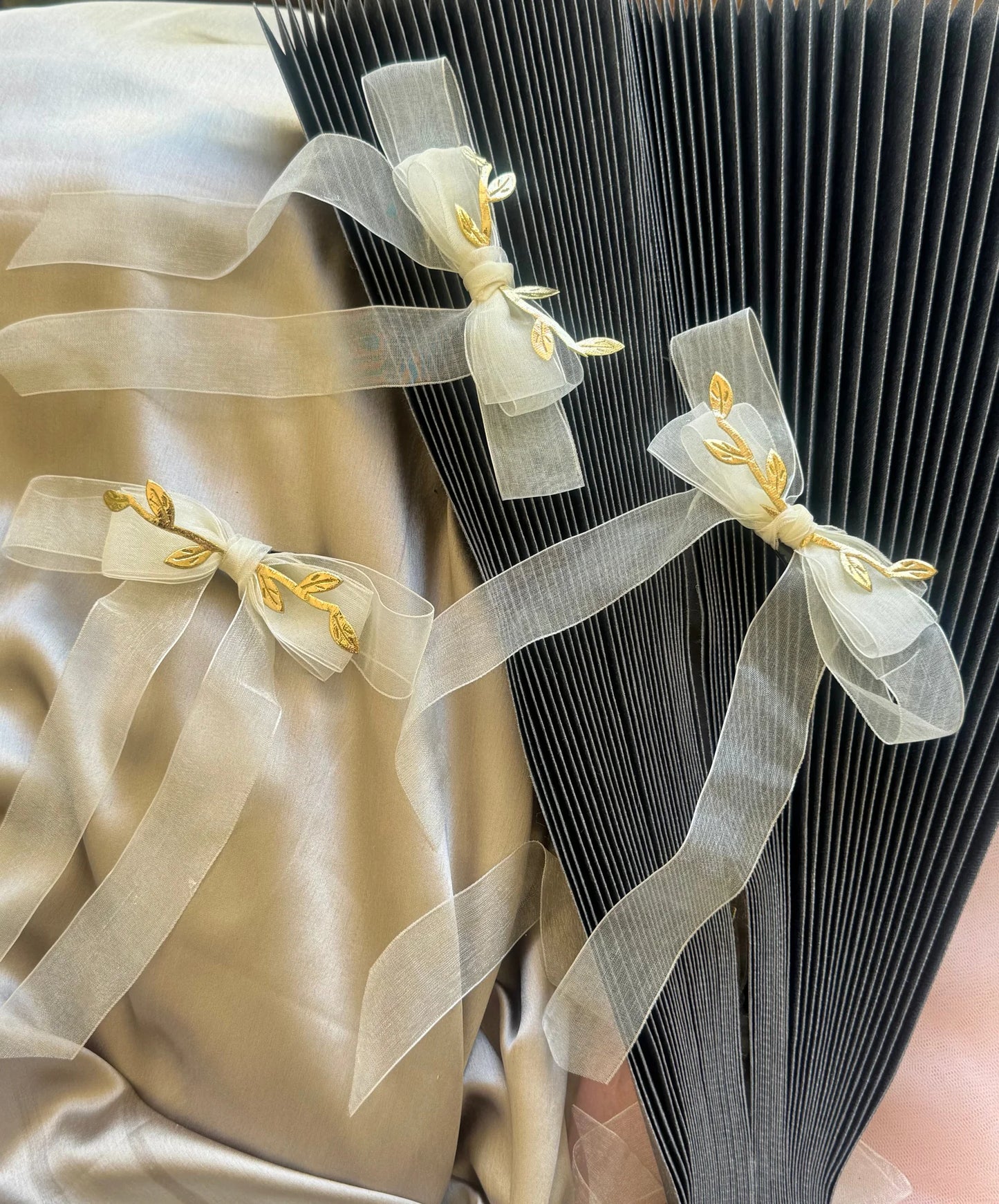 White transparent bow hair clip with gold leaf detail by Bows and Bags India, elegant handmade accessory displayed on