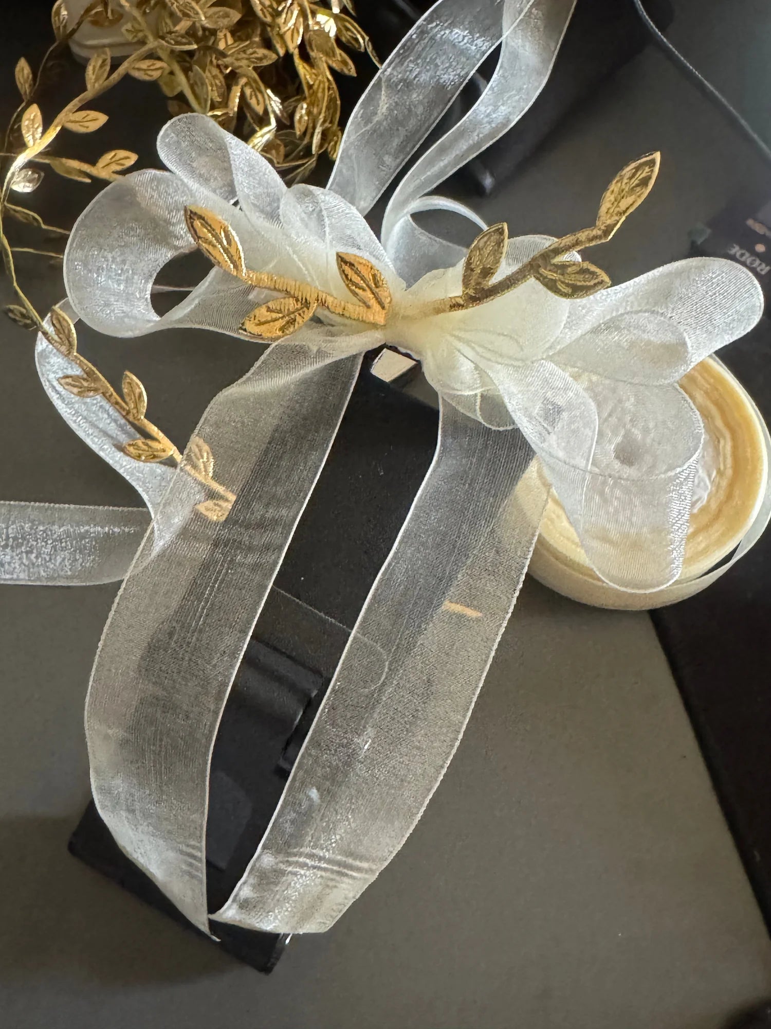 White transparent bow hair clip with gold leaf details by Bows and Bags India, handmade accessory with sheer ribbons