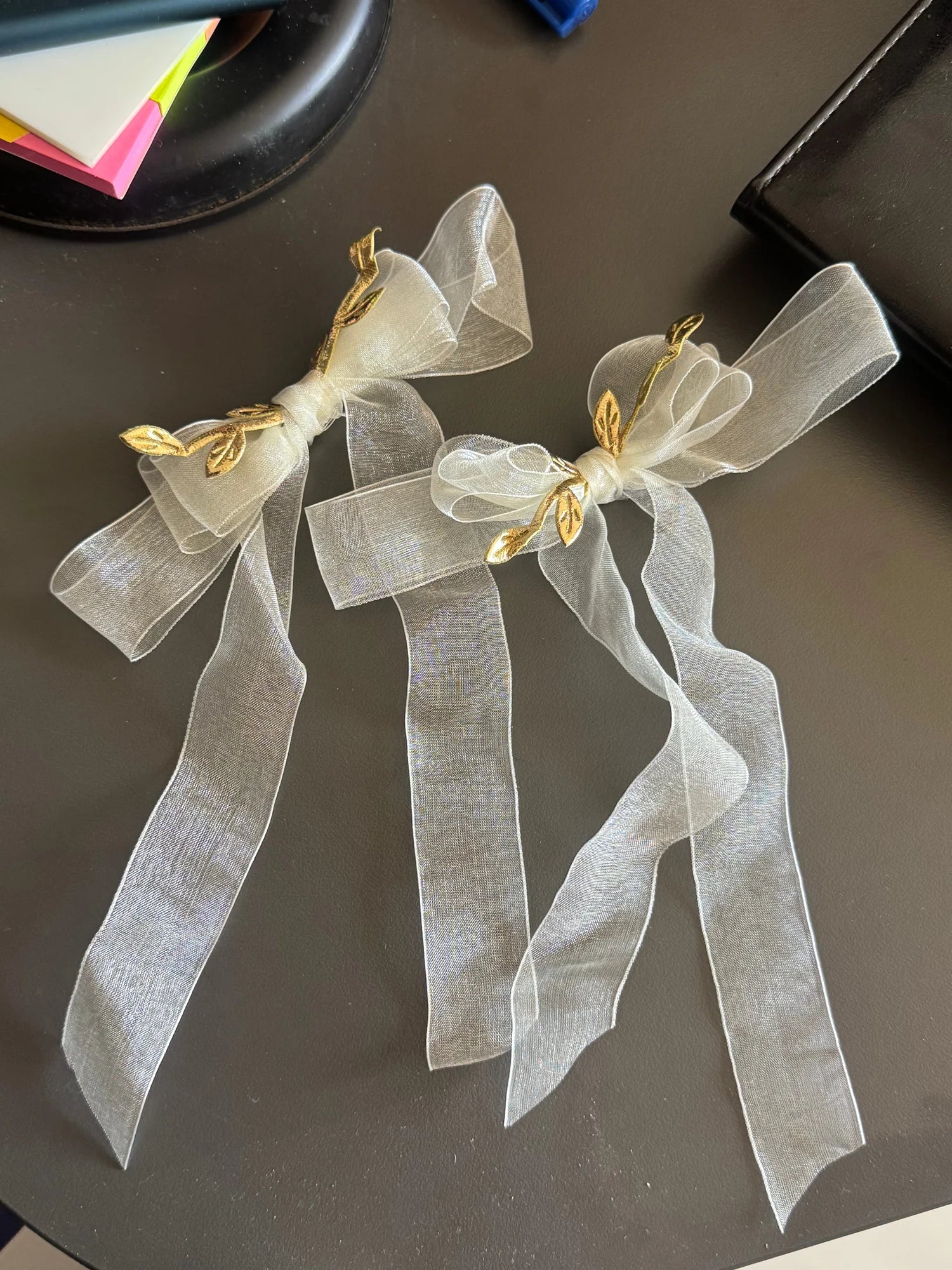 White transparent organza hair bow with gold metal accents by Bows and Bags India, handmade hair clip displayed on dark
