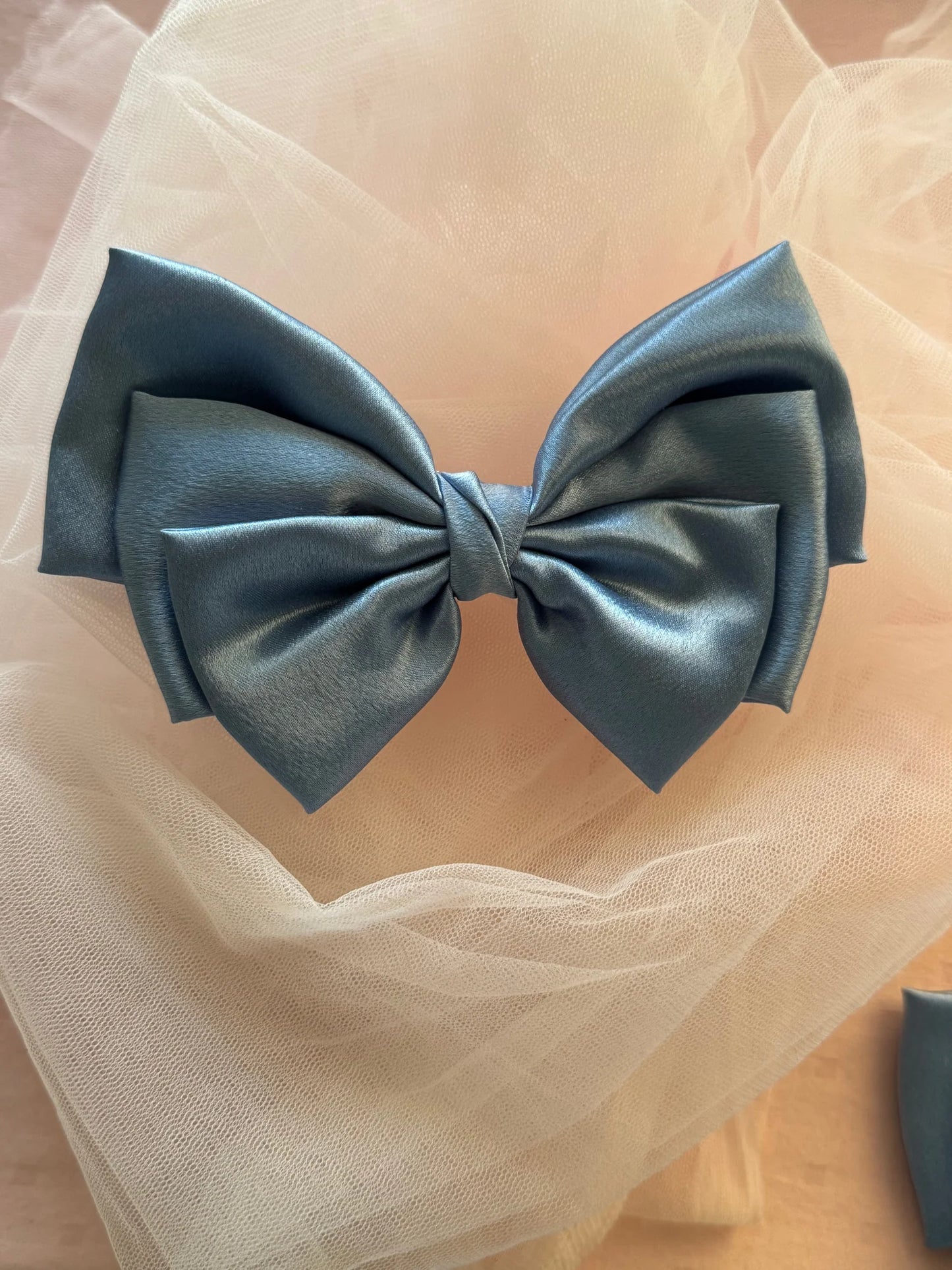 Metallic ice blue satin hair bow by Bows and Bags India on cream tulle, handmade accessory with elegant sheen and