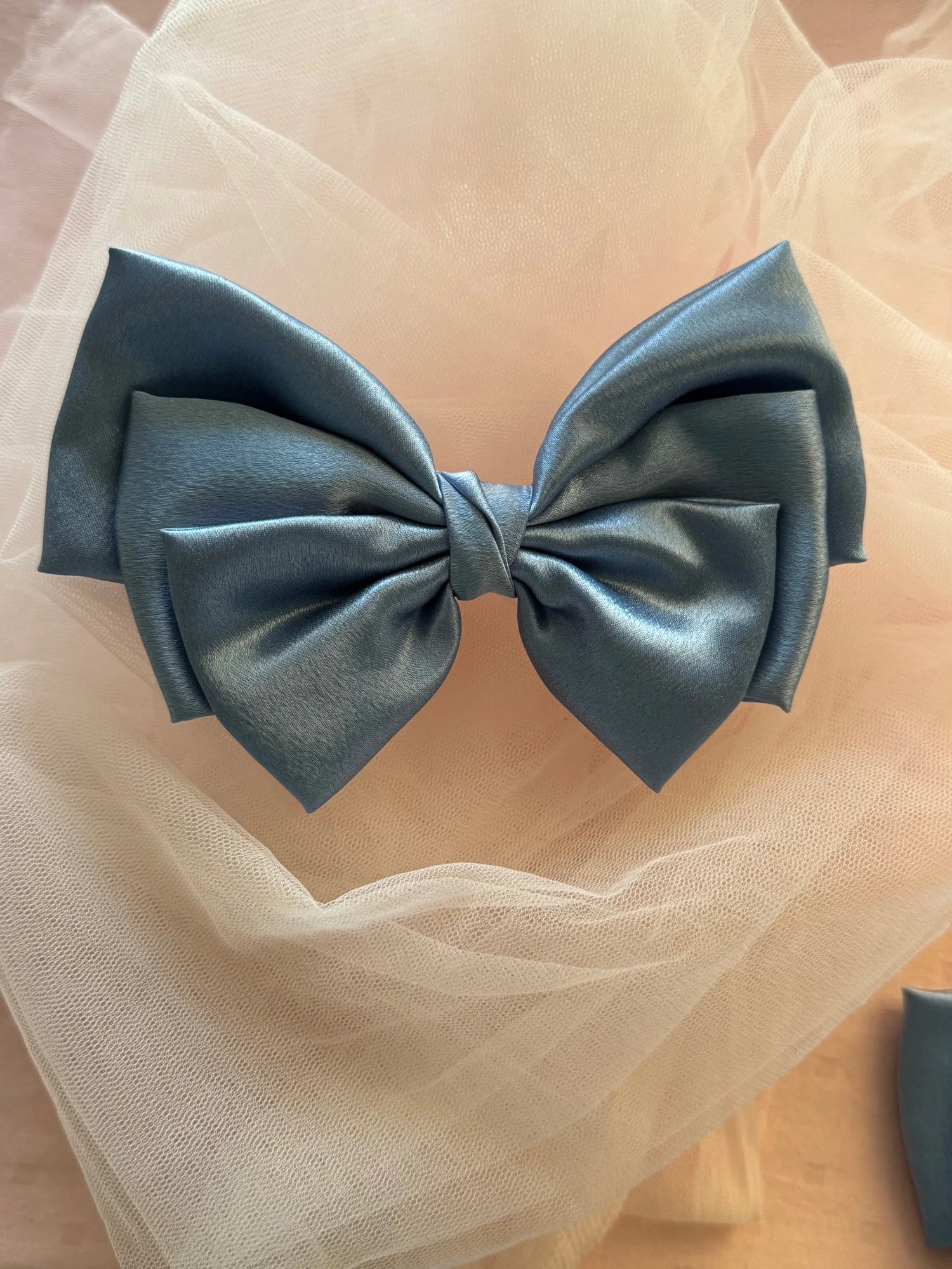 Metallic ice blue satin hair bow by Bows and Bags India on cream tulle, handmade accessory with elegant sheen and