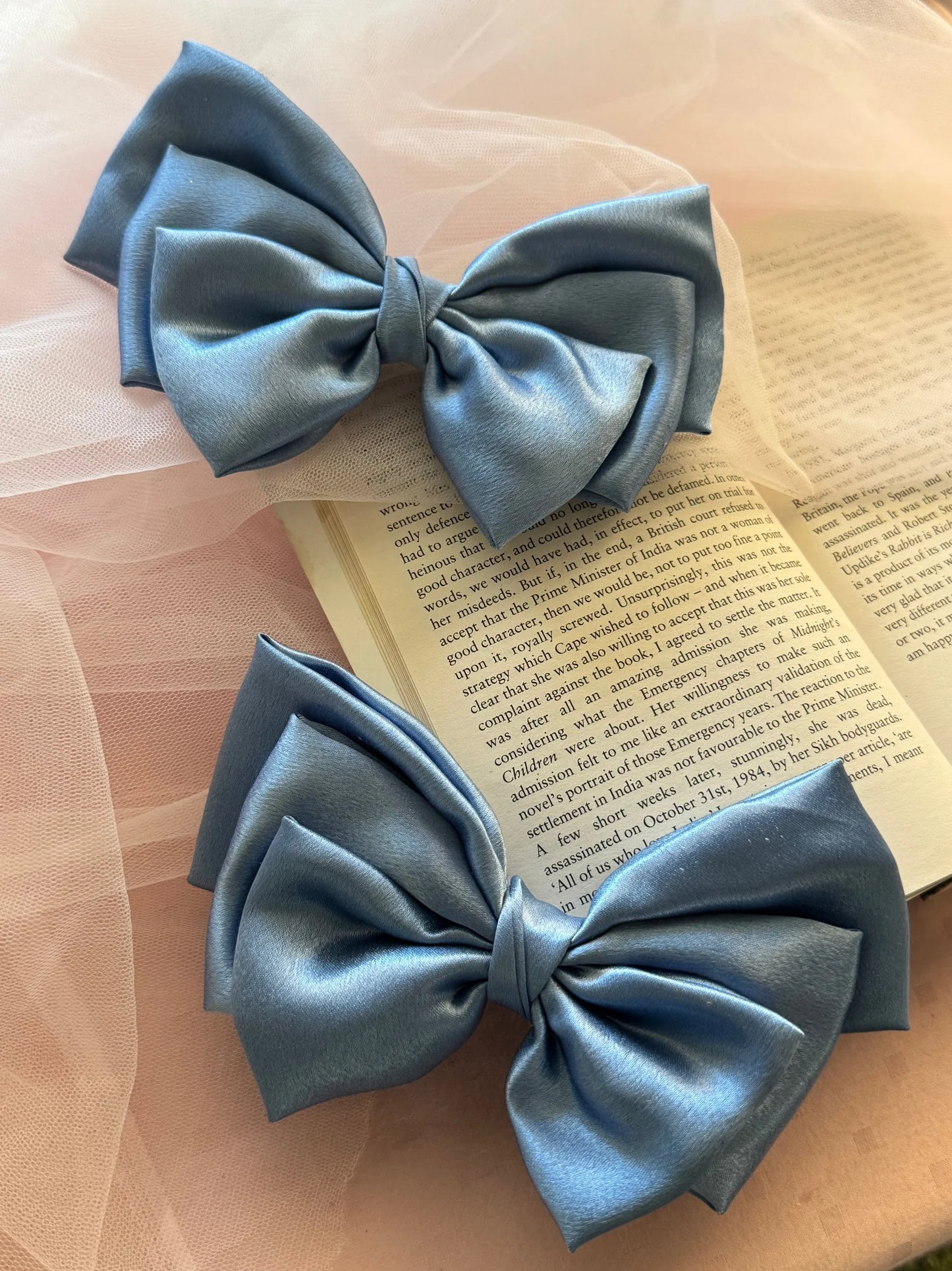 Ocean Drop metallic ice blue satin hair bows by Bows and Bags India displayed on vintage book, handmade accessories