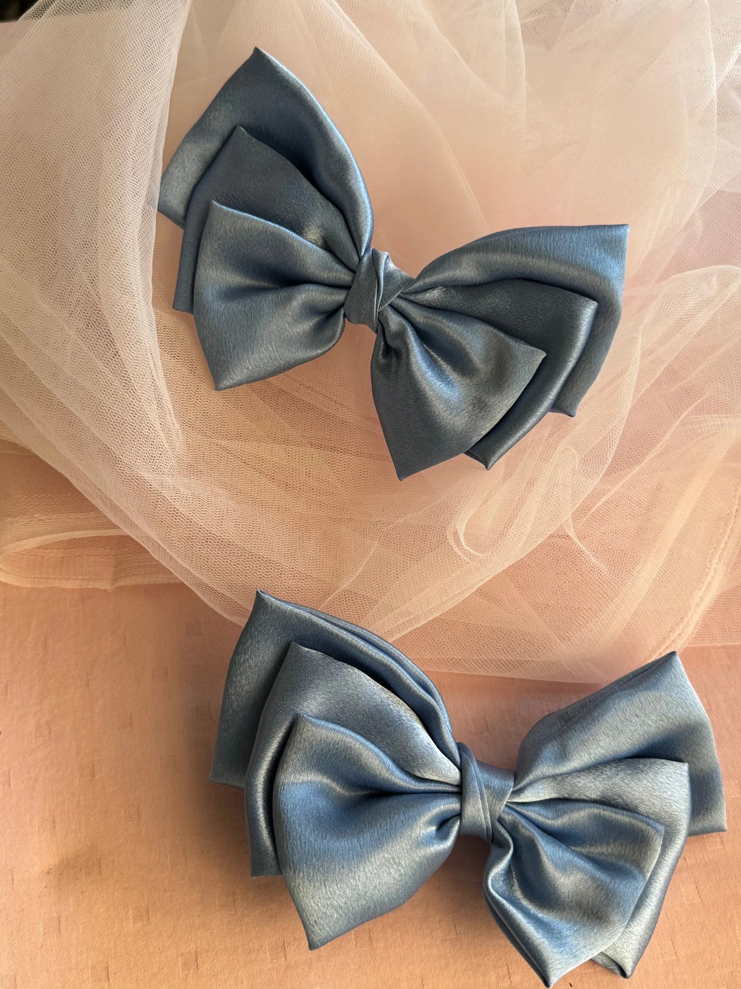 Metallic ice blue satin hair bows by Bows and Bags India displayed on blush tulle, showcasing handmade bow details and