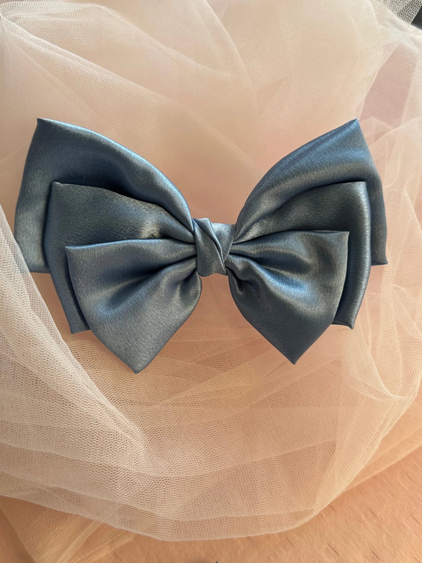Metallic ice blue satin hair bow by Bows and Bags India displayed on cream tulle, showcasing elegant handmade bow texture