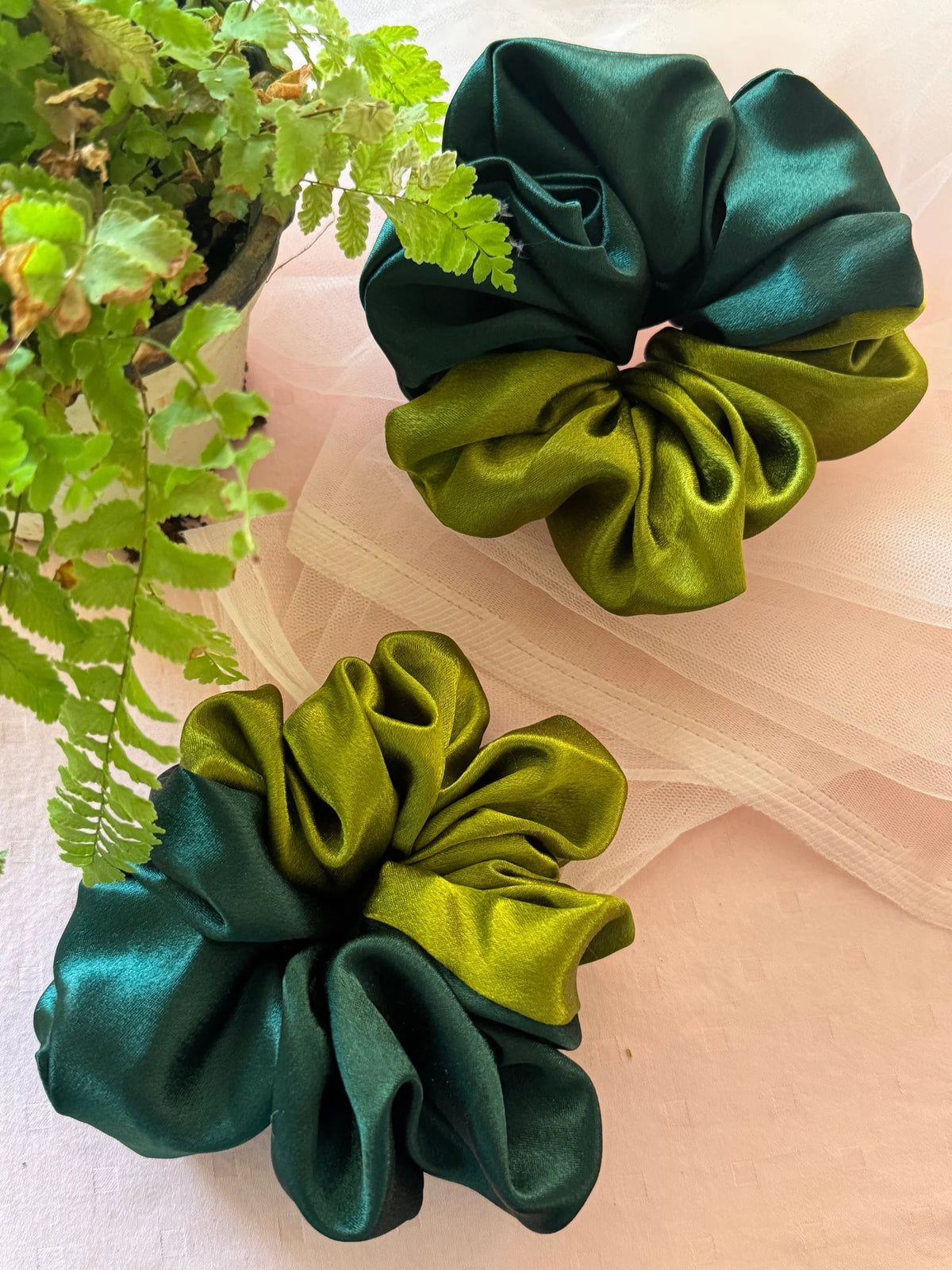 Olive and dark green dual-colour satin scrunchies by Bows and Bags India — handmade hair accessories on neutral fabric