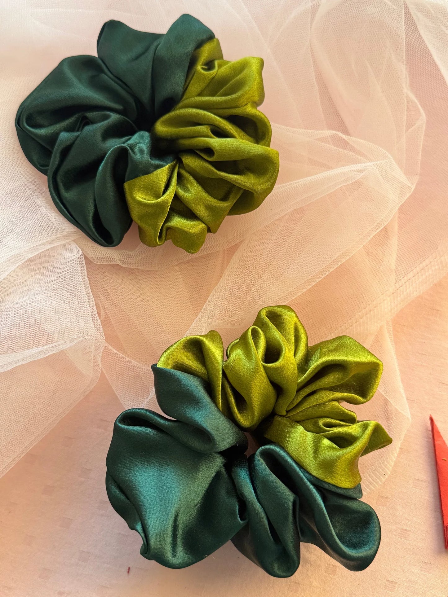 Dual olive and dark green satin scrunchies by Bows and Bags India displayed on sheer fabric, showcasing handmade texture and