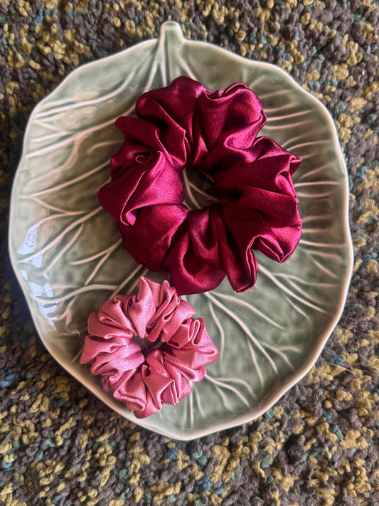 Dark fuchsia and light pink satin scrunchies combo by Bows and Bags India displayed on leaf-shaped dish, handmade hair