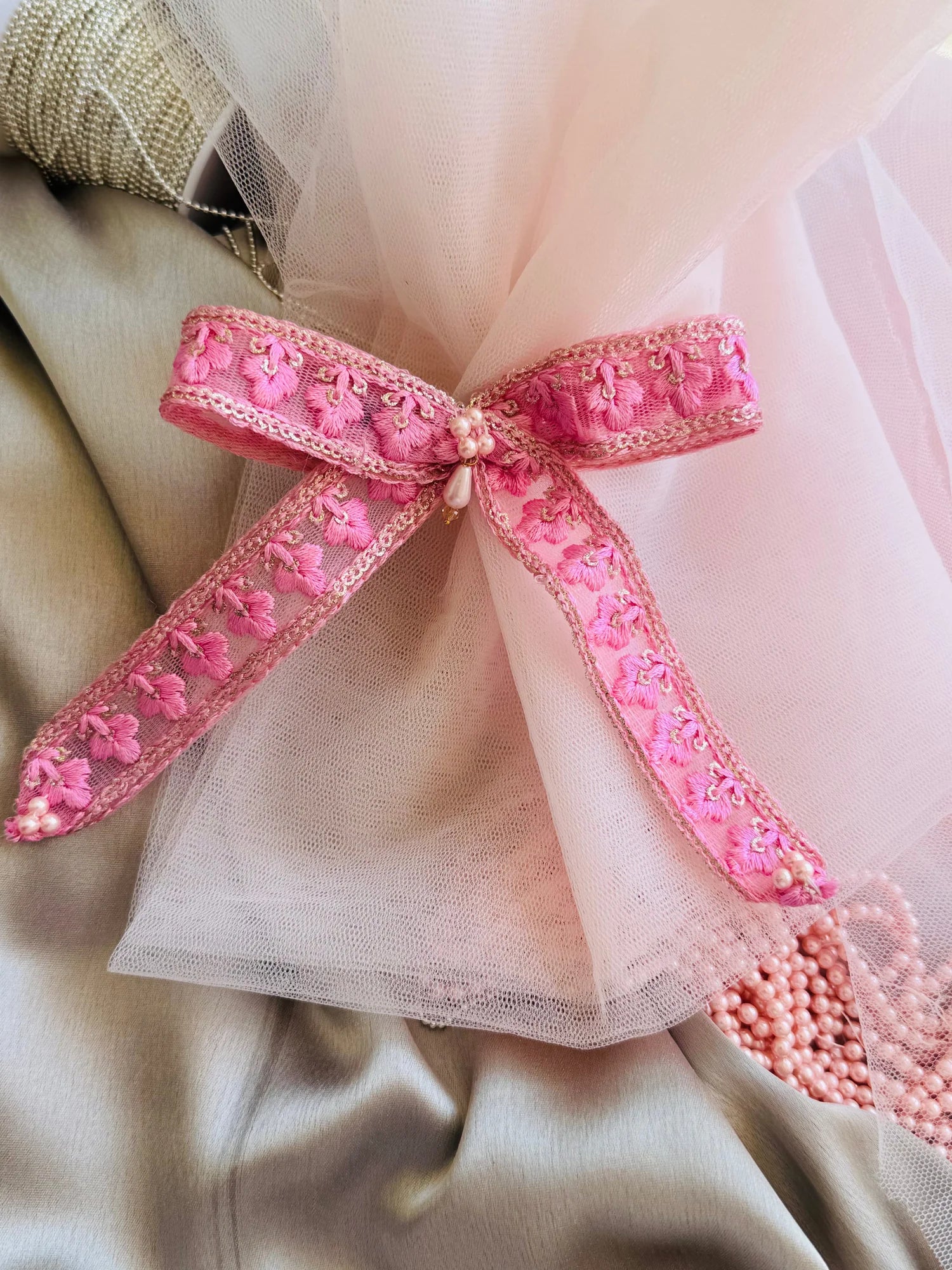 Pink Pearl Flower hair clip with embroidered floral design and pearl center, displayed on tulle fabric by Bows and Bags India