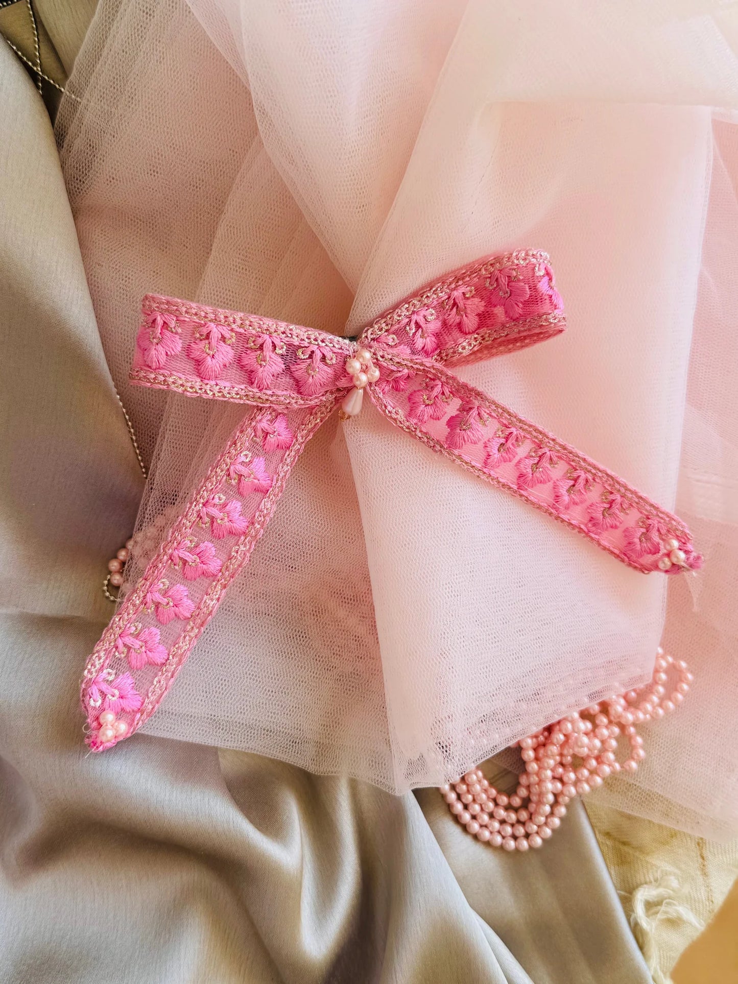 Pink Pearl Flower hair clip with floral embroidery and pearl detail, styled elegantly with tulle and pearl accessories by