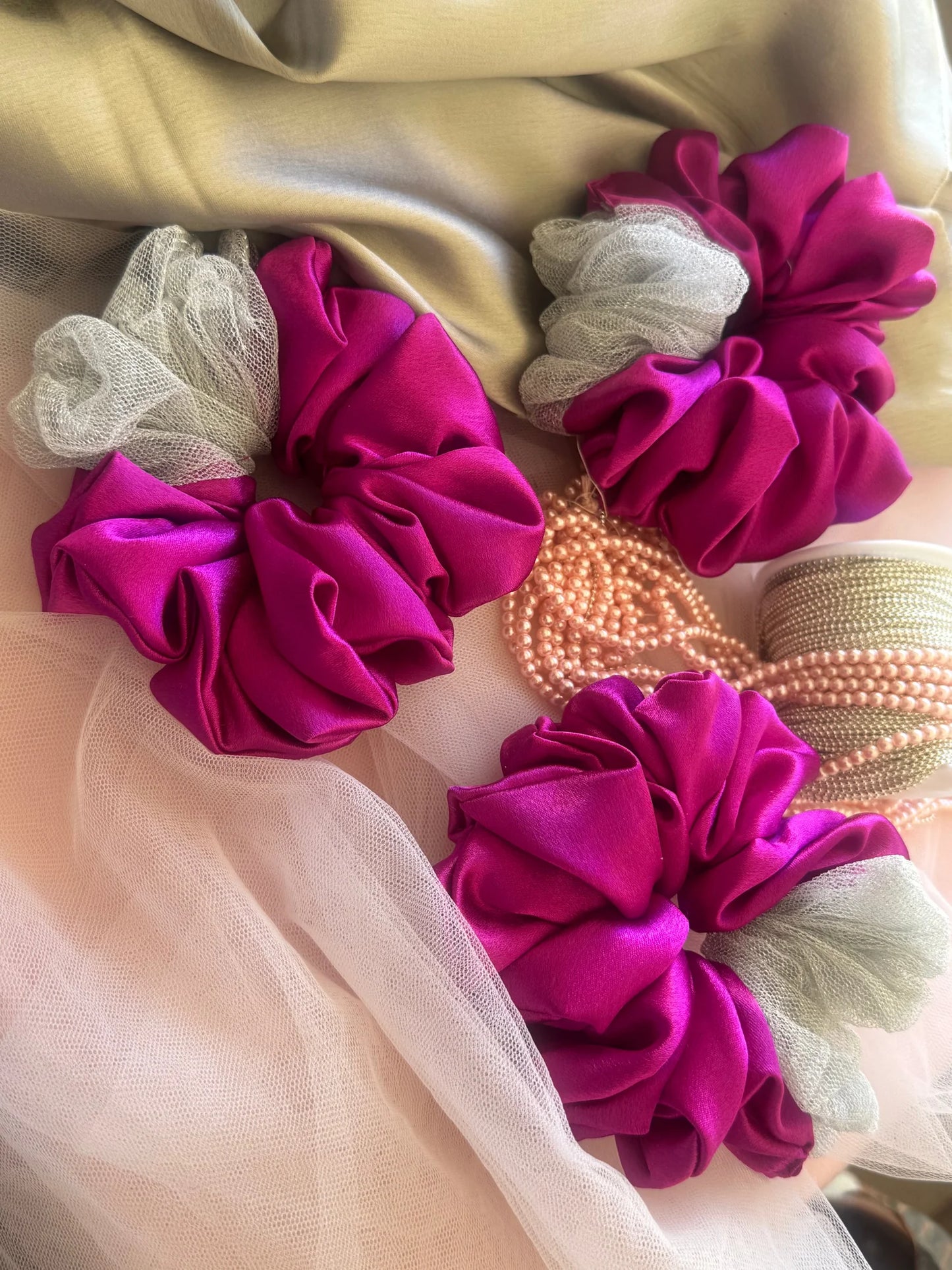 Three vibrant pink satin scrunchies with silver net details and pearl beads from Bows and Bags India handmade hair