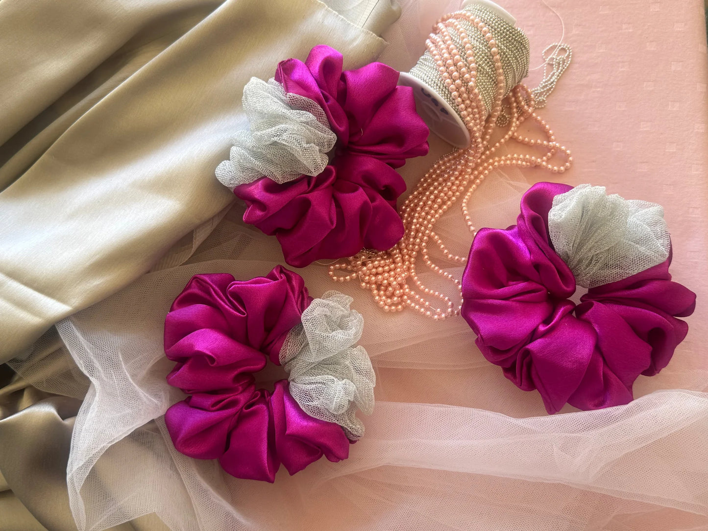 Pink silver satin scrunchies with net detail and pearl beads by Bows and Bags India handmade hair accessories styled flat lay