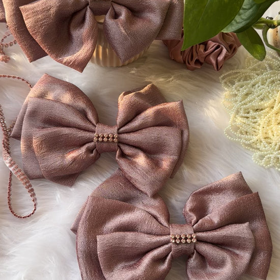 Close-up video of a Rose Gold Satin Hair Bow with elegant stone detailing, showcasing its luxurious Vichitra silk fabric and strong grip clip in 10 seconds