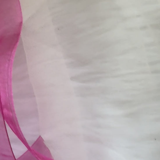 Close-up video of the Pink Crush Hair Bow Clip, showcasing its delicate pink fabric and elegant pearl-accented center for a feminine and chic look.