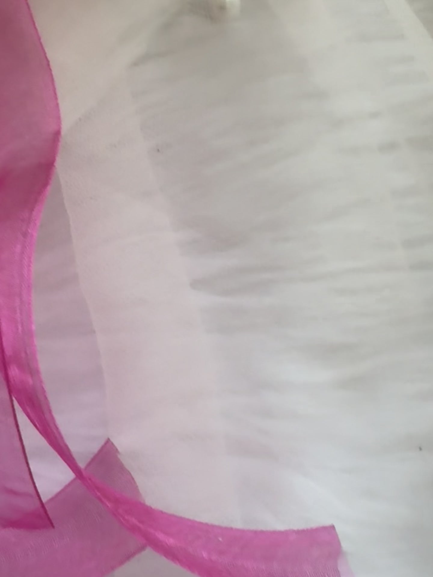 Close-up video of the Pink Crush Hair Bow Clip, showcasing its delicate pink fabric and elegant pearl-accented center for a feminine and chic look.