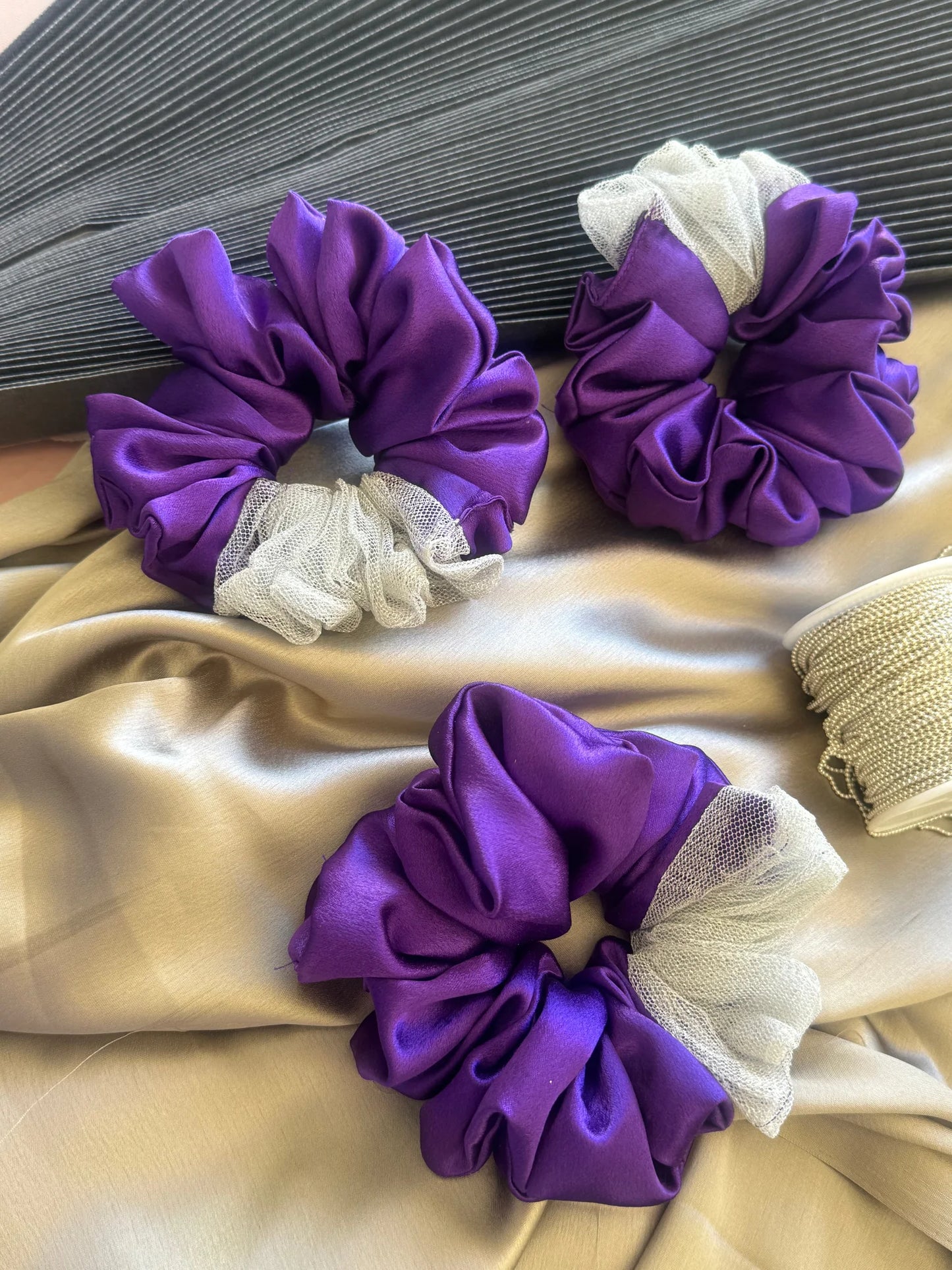 Purple satin and silver net scrunchies with mesh accents by Bows and Bags India, handmade hair accessories displayed on
