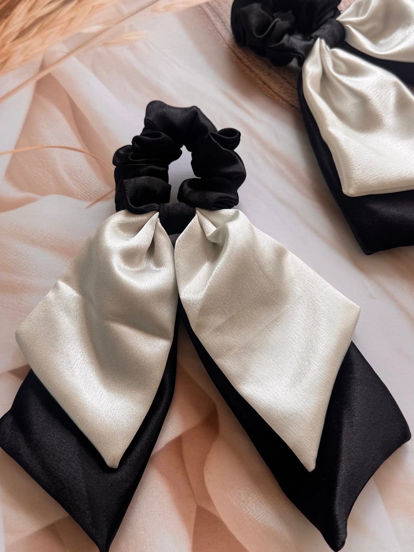 Black and white satin dual long tail scrunchies by Bows and Bags India, handmade bow hair accessories displayed flat lay on