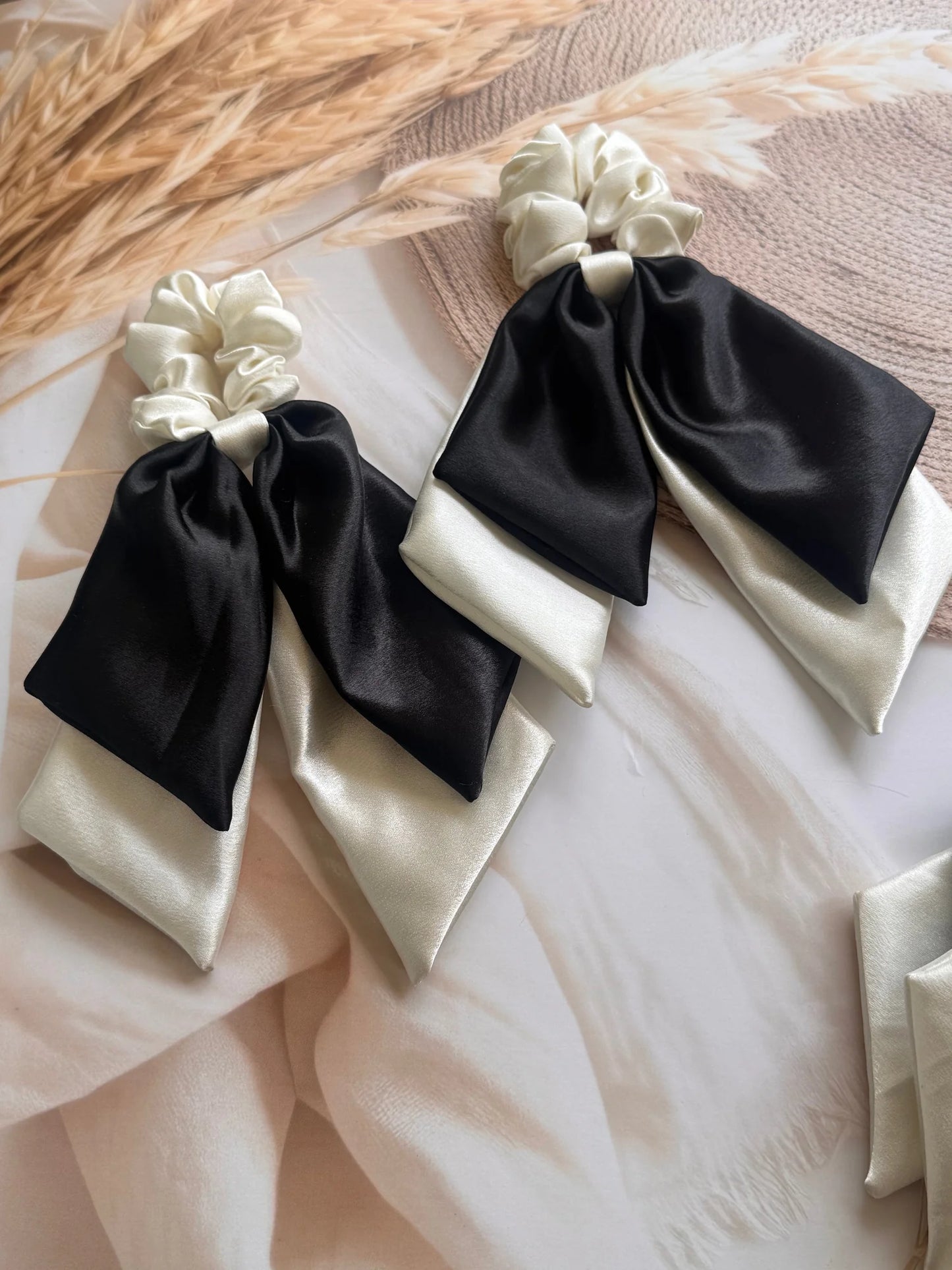 Two black and white satin dual tail scrunchies with pearly bows by Bows and Bags India, handmade hair accessories displayed