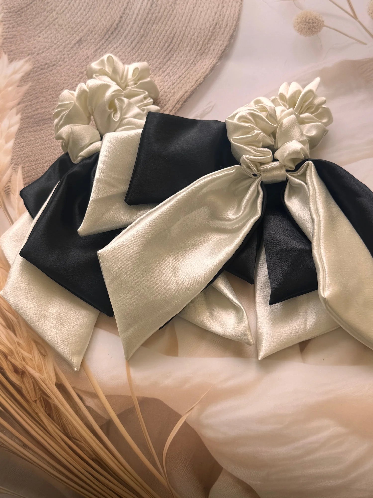 White and black satin dual long tail scrunchie with bow detail by Bows and Bags India, handmade hair accessory on cream
