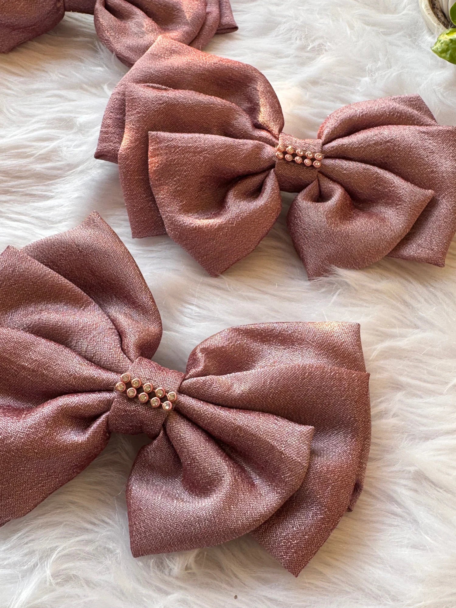 Rose gold silk hair bows with pearl stone detail by Bows and Bags India, handmade accessories on white fur background