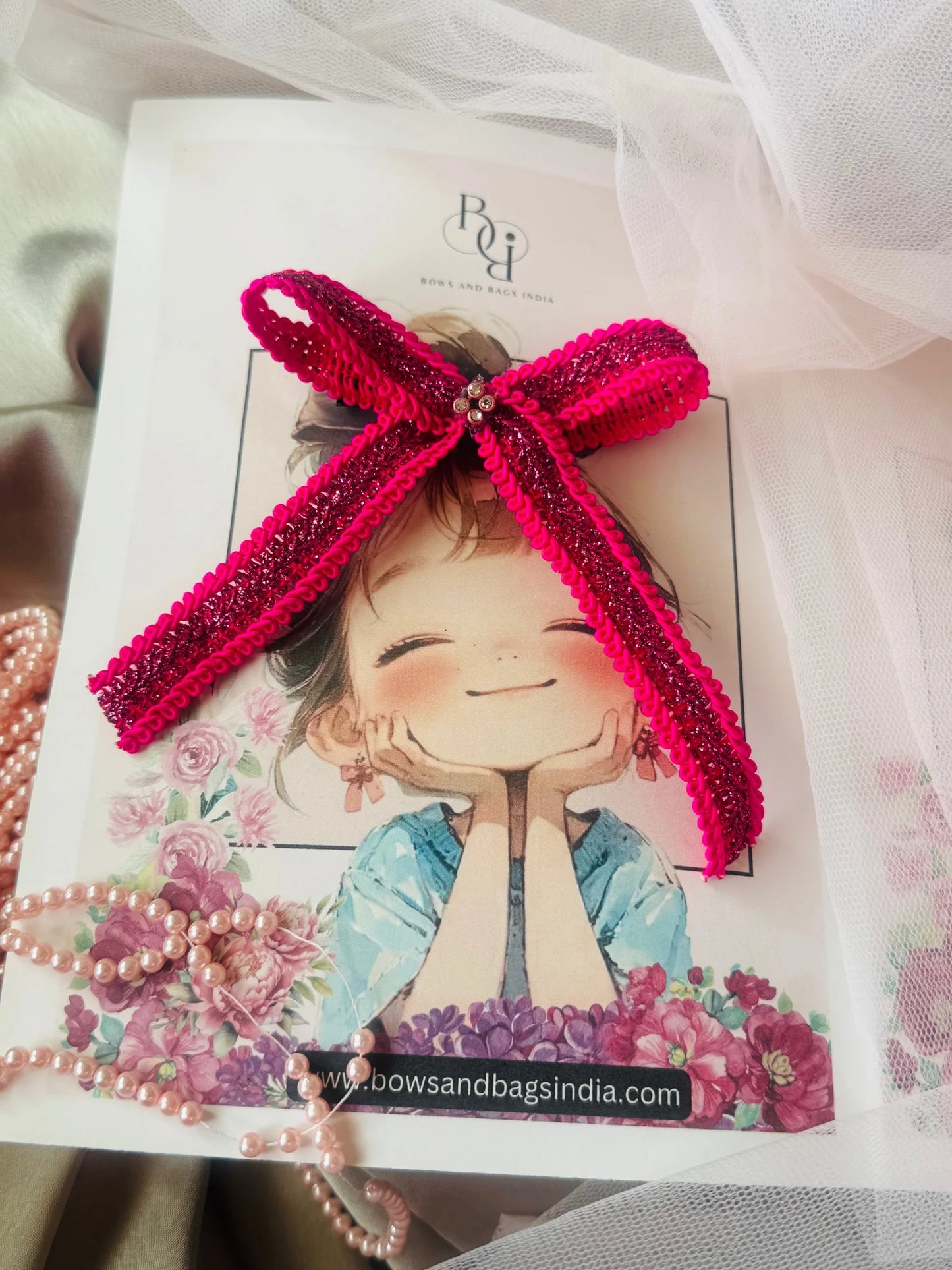 Rose Roosevelt handmade pink sequin hair bow with purple gold details by Bows and Bags India, displayed on illustrated girl