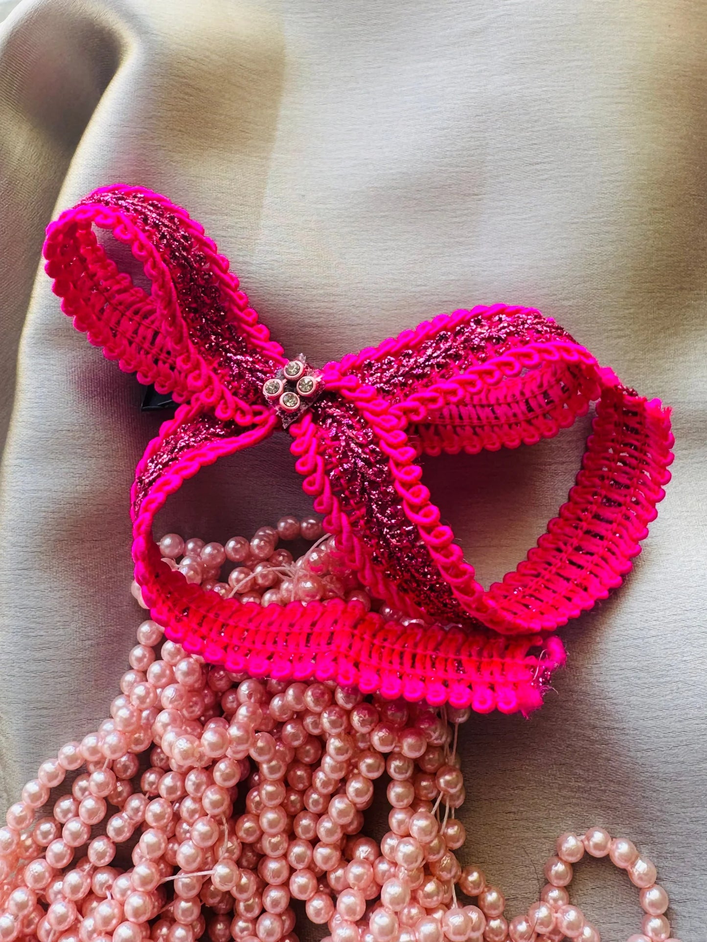 Rose Roosevelt handmade hair bow with vibrant pink ruffled trim, gold glitter, and pearl bead details by Bows and Bags India