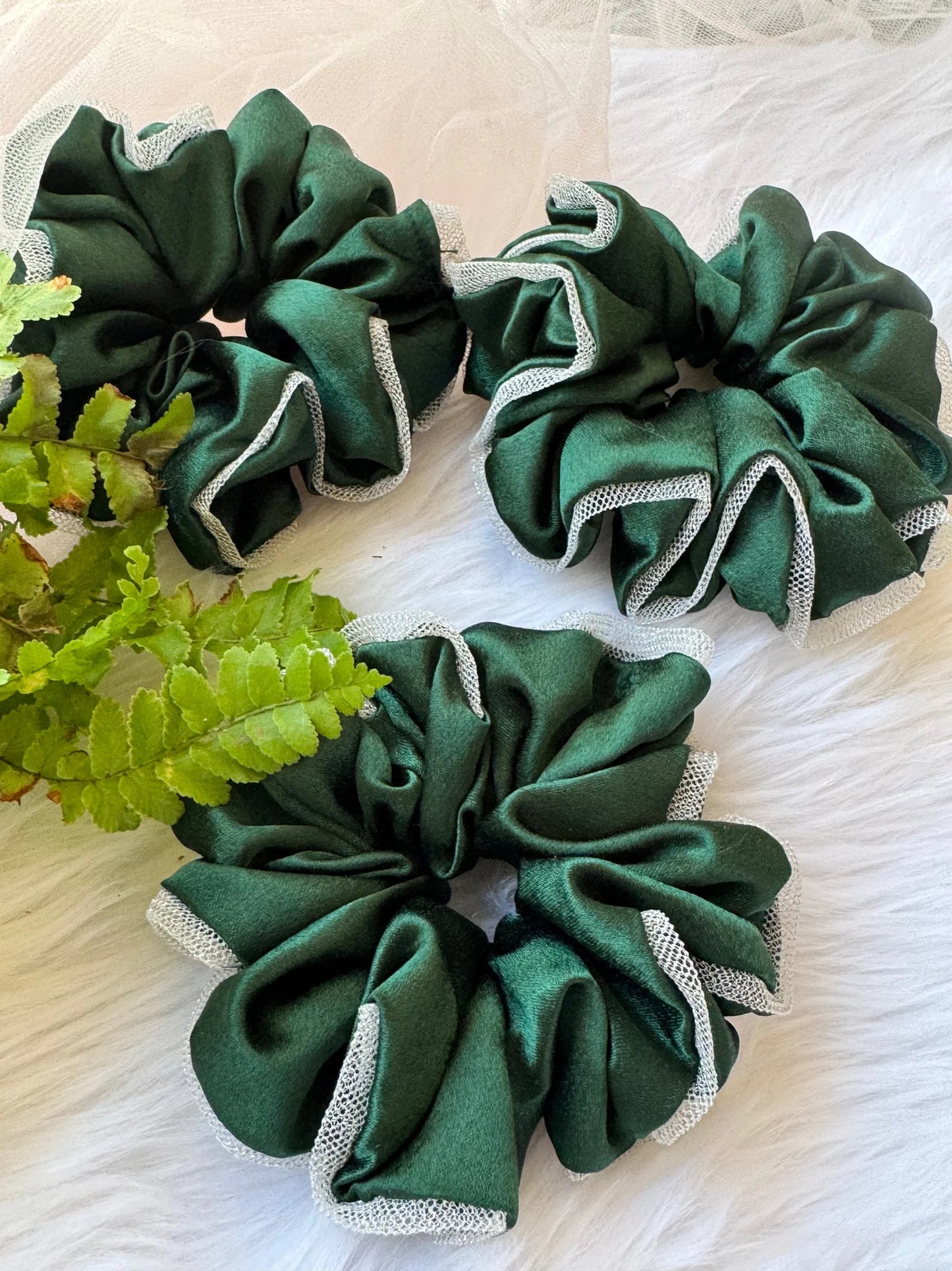 Dark green satin scrunchies with silver net borders, handmade hair accessories by Bows and Bags India displayed with fresh