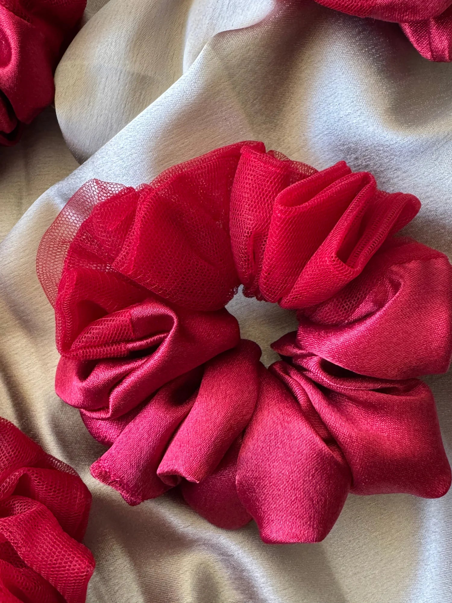 Crimson red satin scrunchie with sheer net detailing by Bows and Bags India, showing luxurious handmade texture and elegant