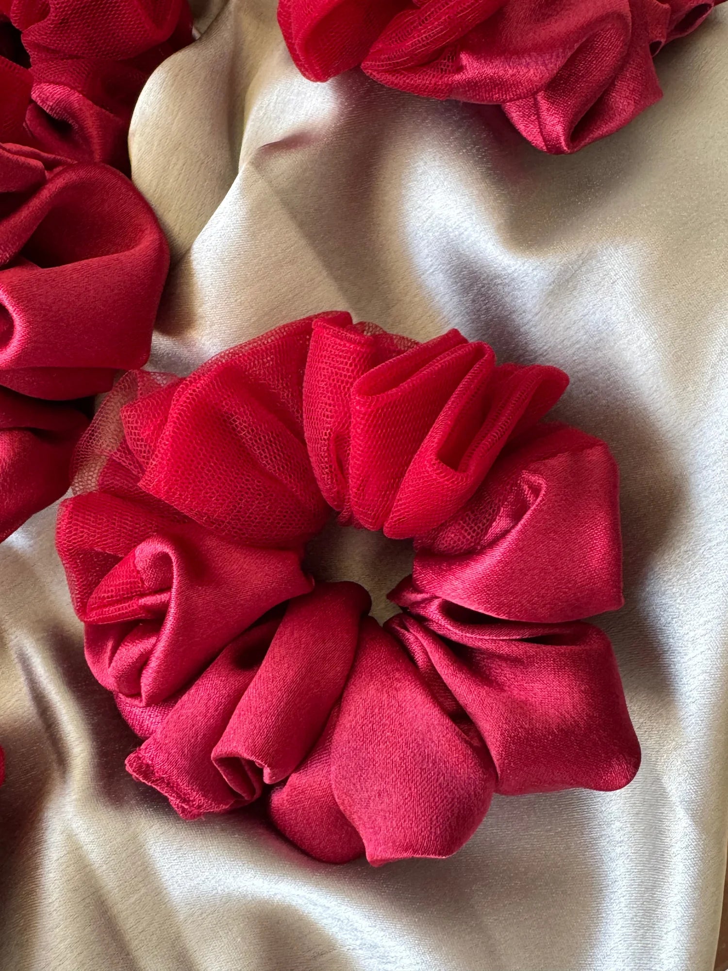 Crimson red satin scrunchie with net detailing on cream fabric, Bows and Bags India handmade hair accessory close-up texture